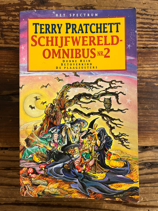 Voorkant van boek met titel 'Terry Pratchett Schijfwereld Omnibus No. 2' op houten achtergrond 