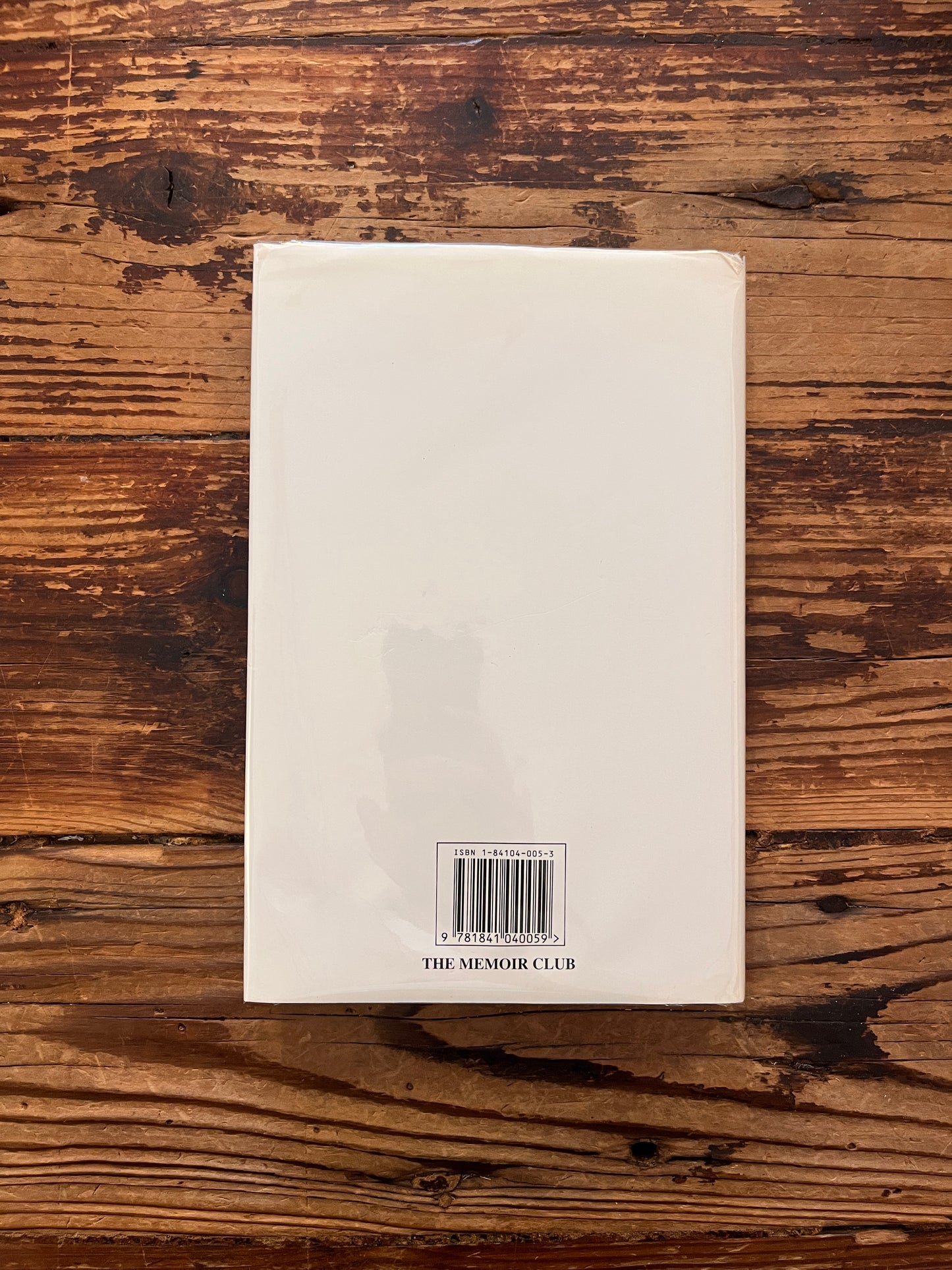 Front cover (with dust jacket) of book with the title 'Tyro on the Trucial Coast' by Julian Walker on a wooden surface