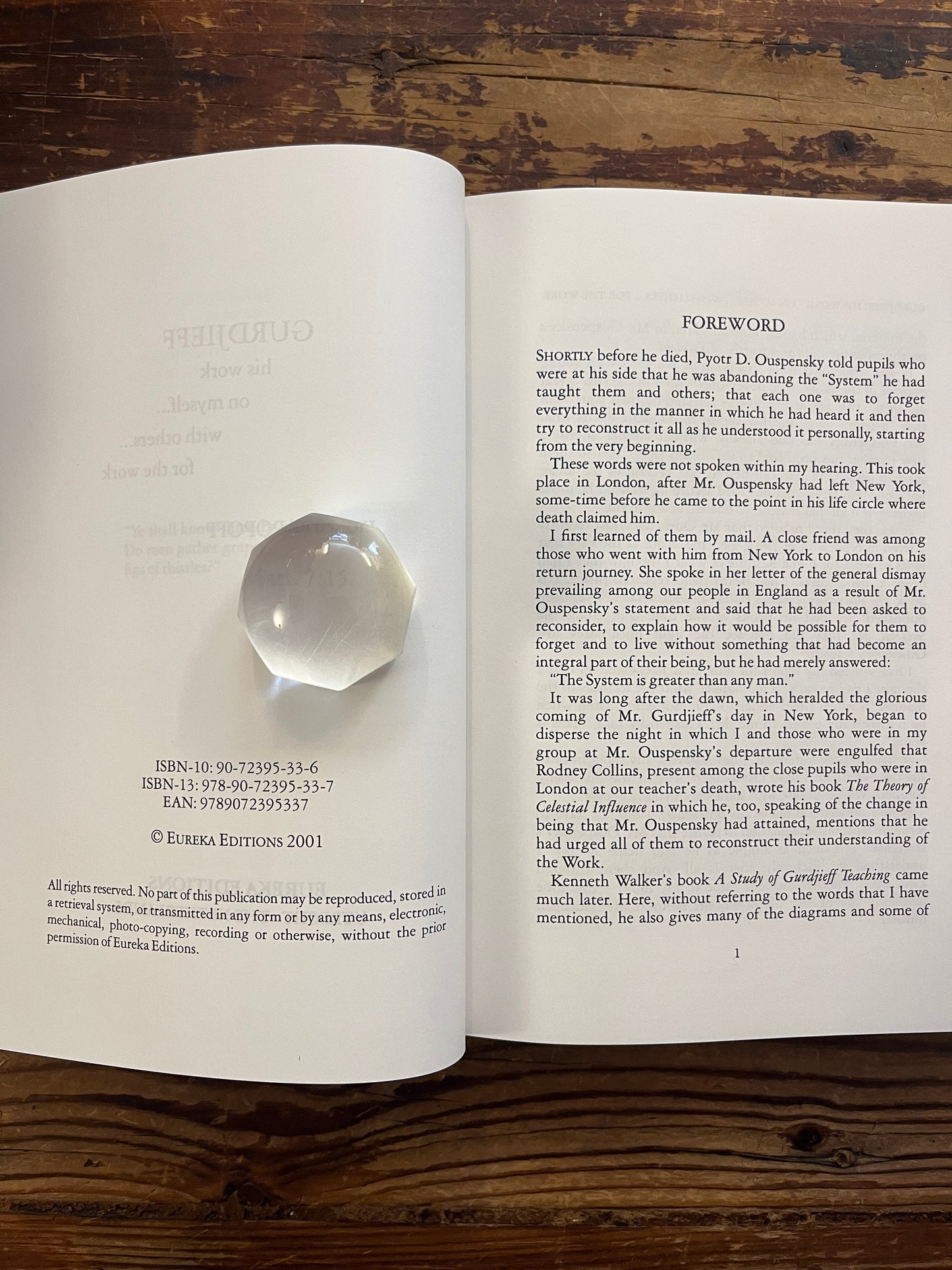 Open book titled 'Gurdjieff, His work, on myself, with others, for the work' by Irmis B. Popoff on a wooden surface