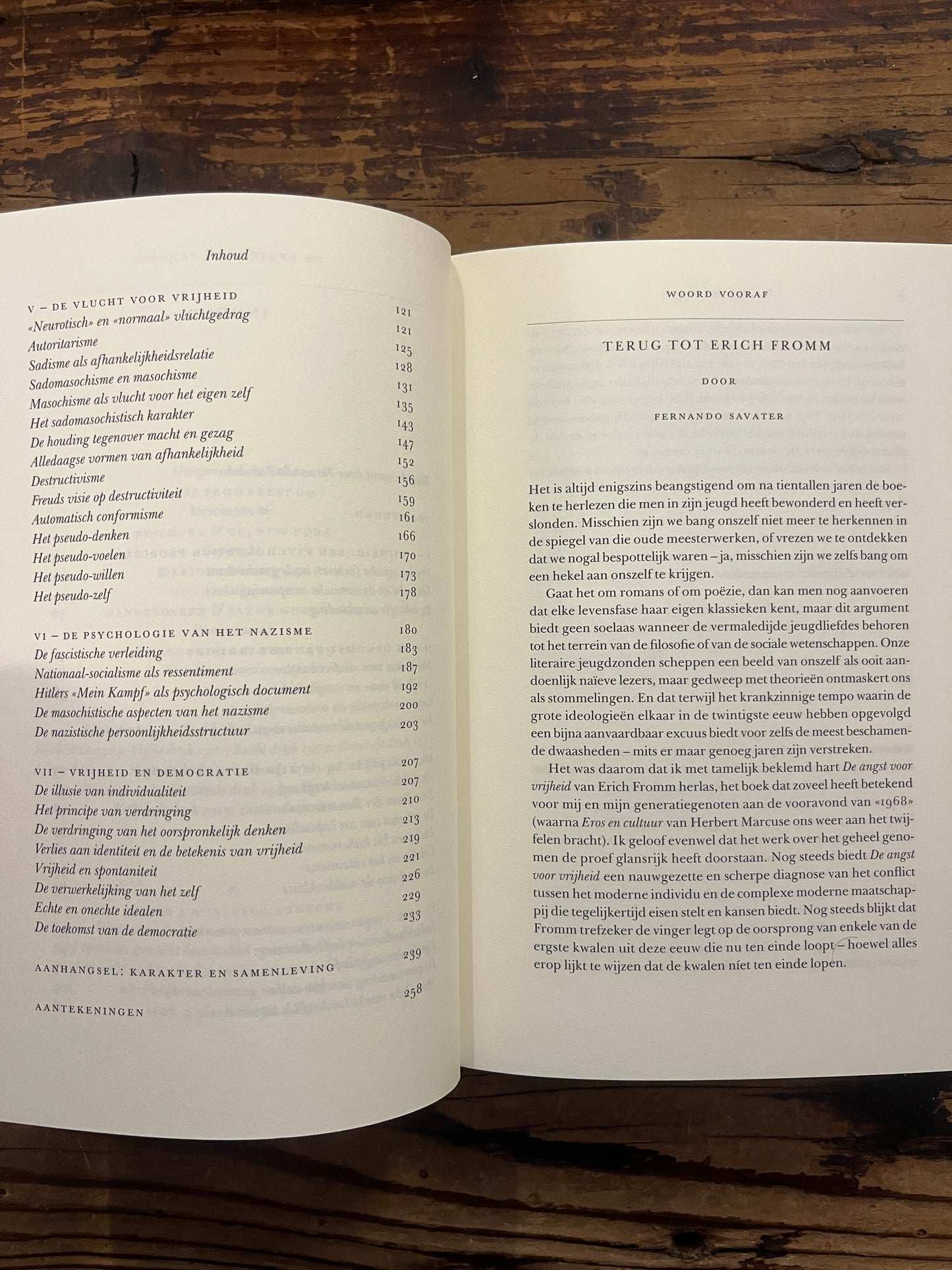 Open boek met de titel 'De Angst voor Vrijheid' door Erich Fromm op een houten achtergrond