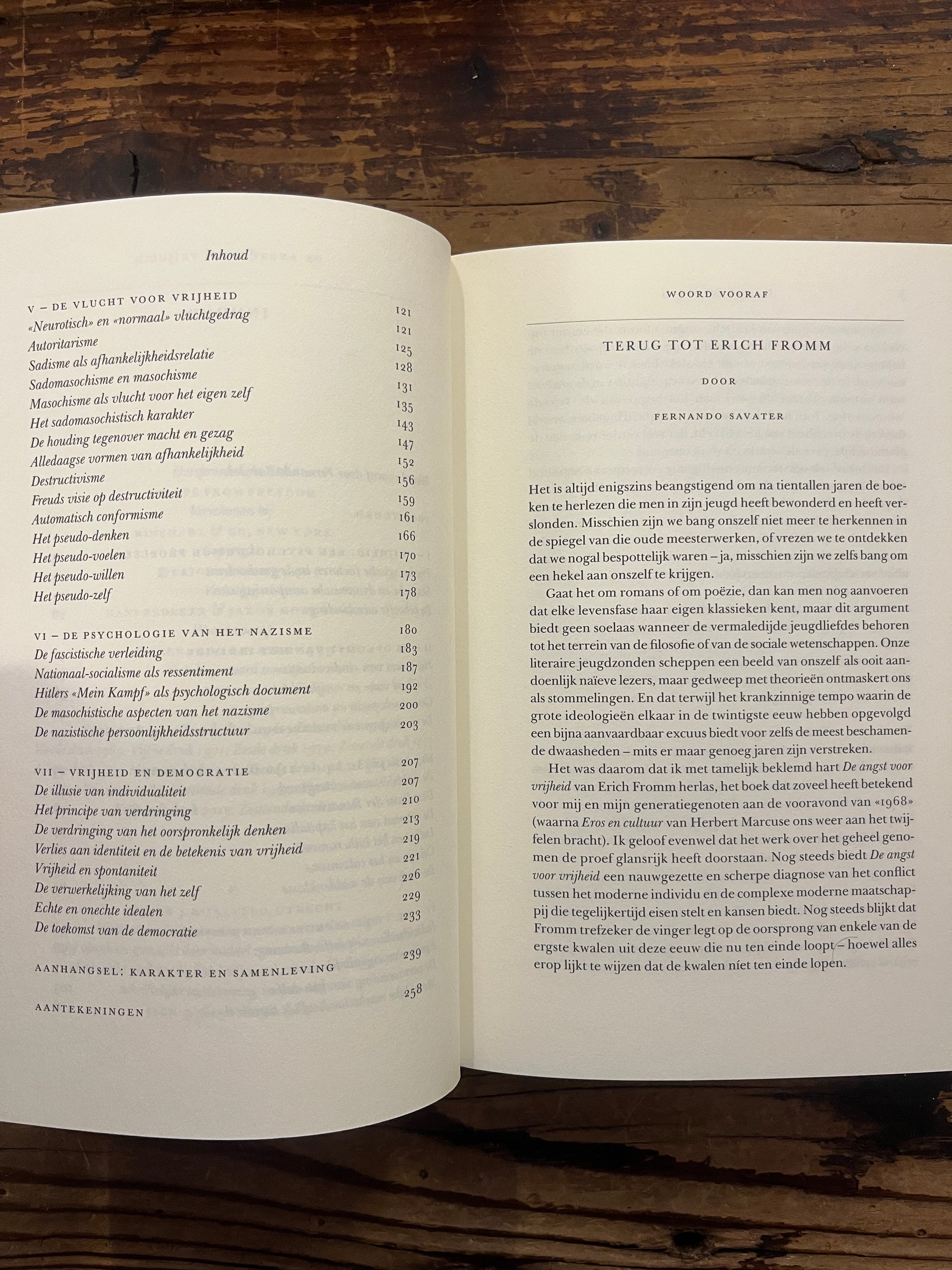 Open boek met de titel 'De Angst voor Vrijheid' door Erich Fromm op een houten achtergrond