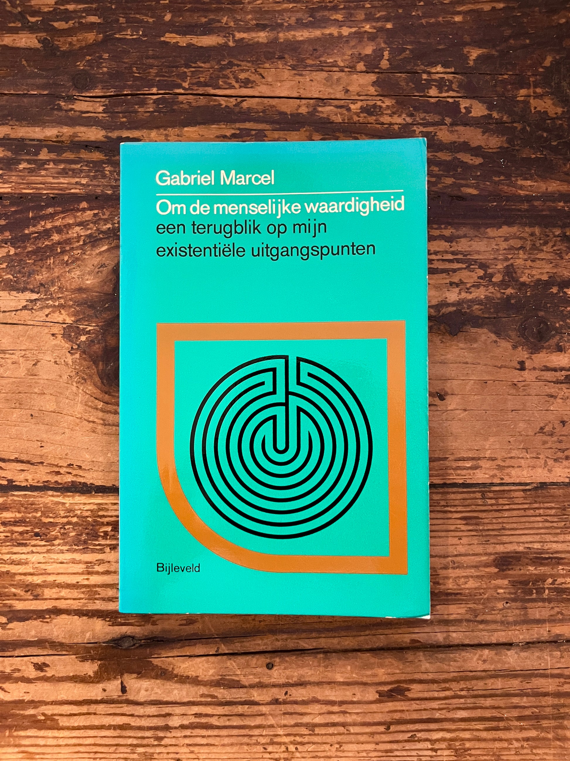 foto van de omslag van het boek "om de menselijke waardigheid" op houten achtergrond