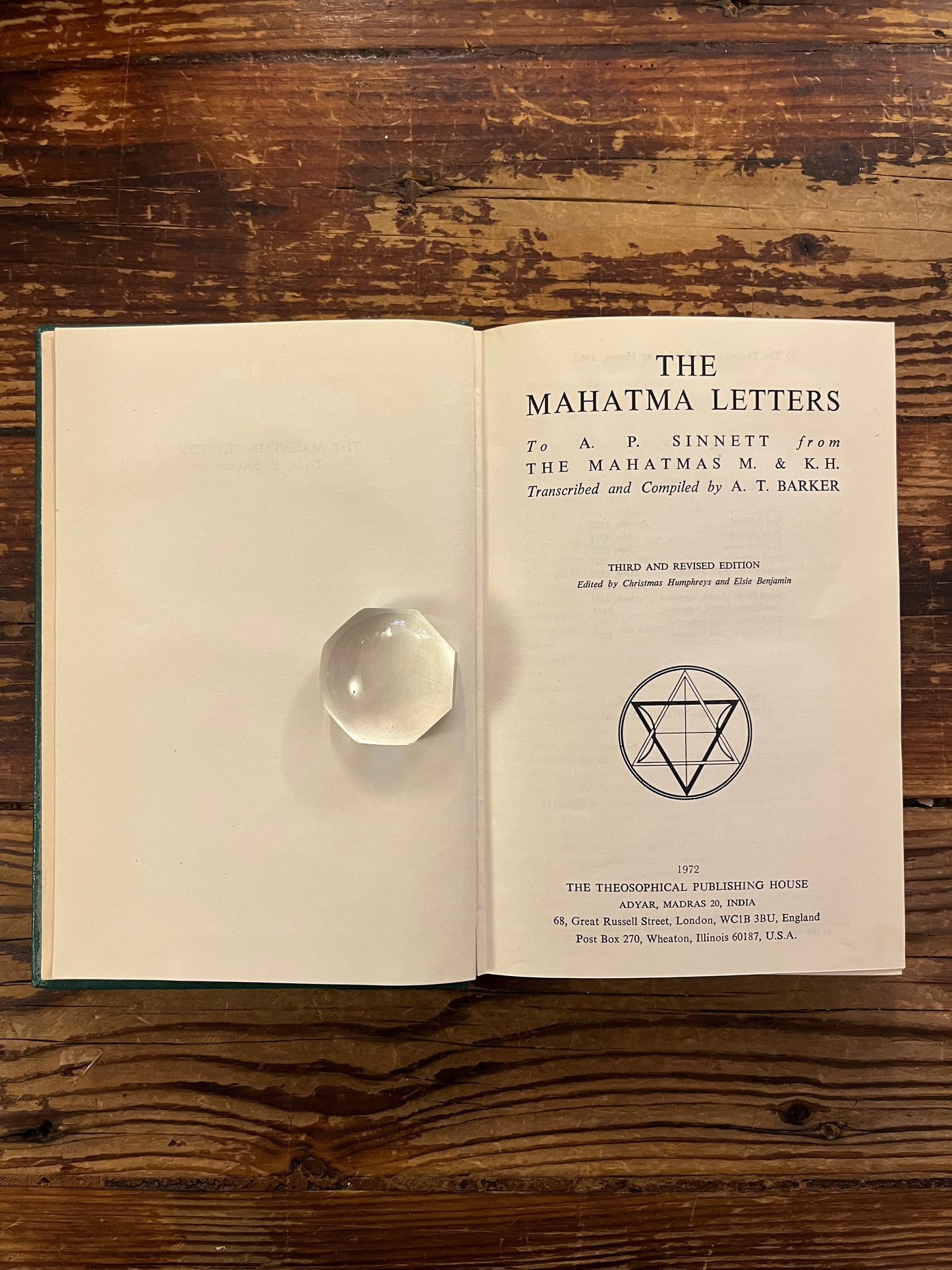Open book titled 'the Mahatma letter to A.P. Sinnett' on a wooden surface 