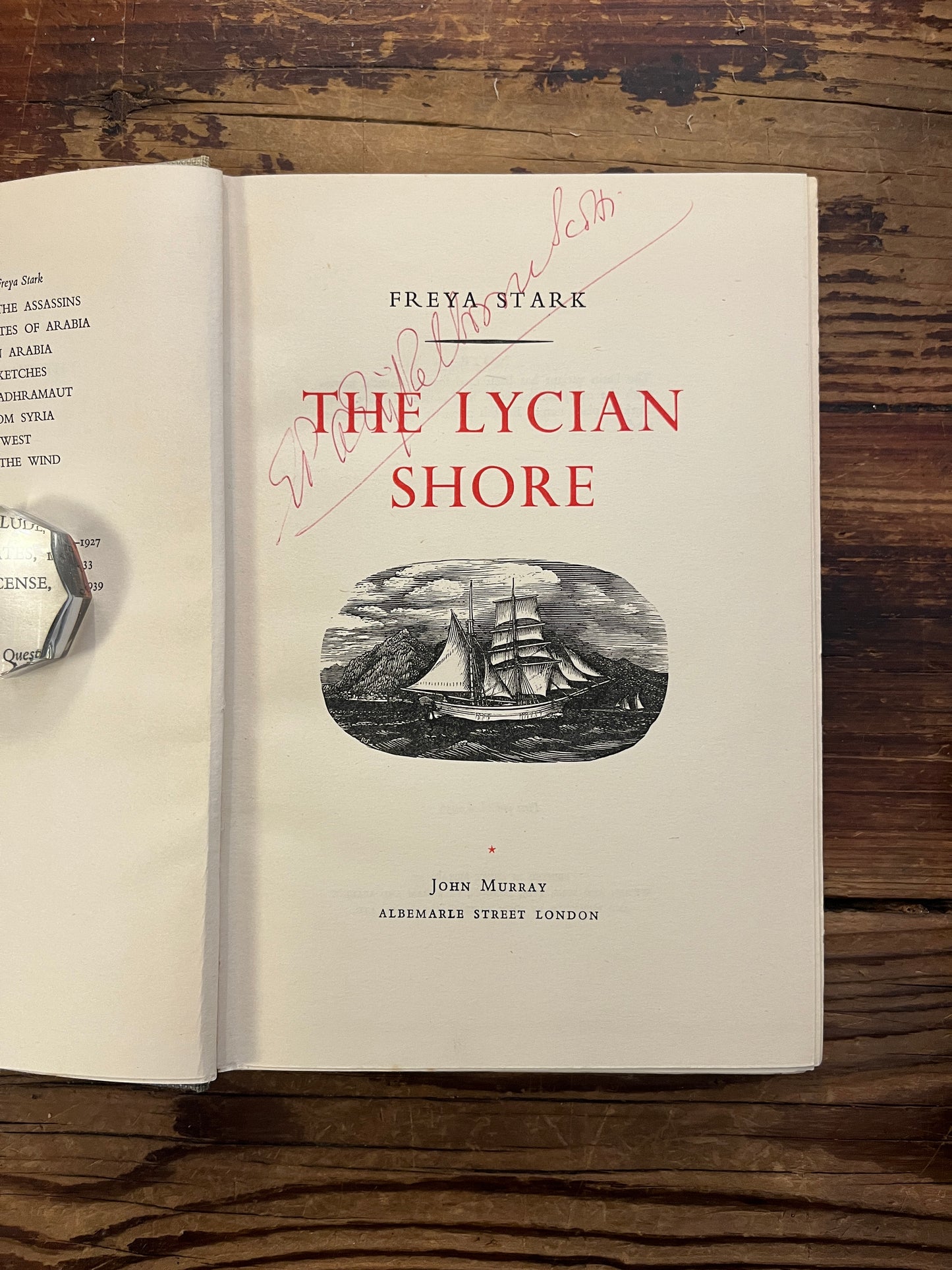 Open book titled 'The Lycian Shore' by Freya Stark on a wooden surface