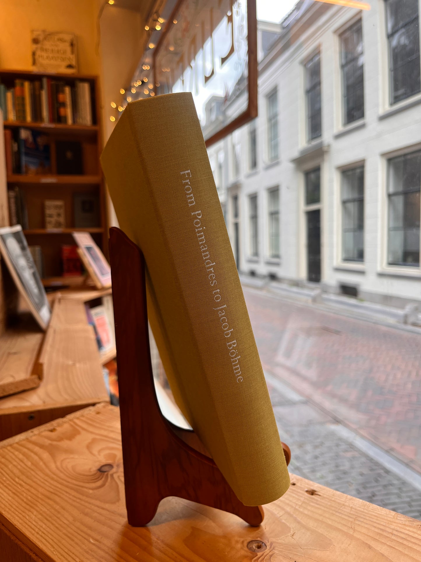 Spine of book titled 'From Poimandres to Jacob Böhme: Gnosis, Hermetism, and the Christian tradition Edited by Roelof van den Broek and Cis van Heertum' in front of a window 