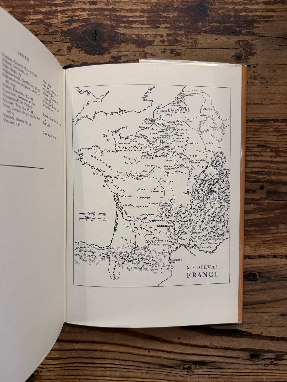 Open book titled 'Life in Medieval France' by Joan Evans, on a wooden surface