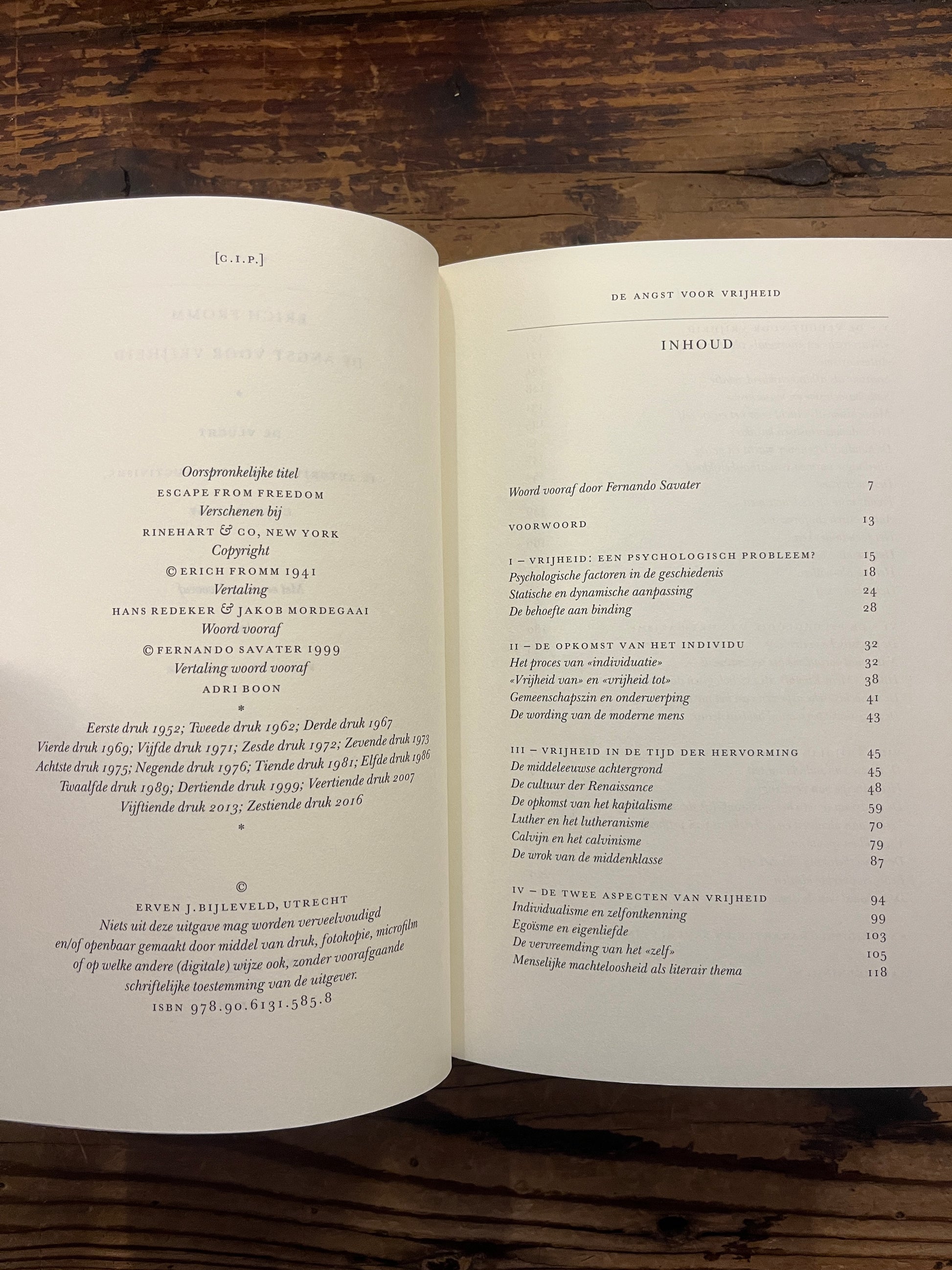 Open boek met de titel 'De Angst voor Vrijheid' door Erich Fromm op een houten achtergrond