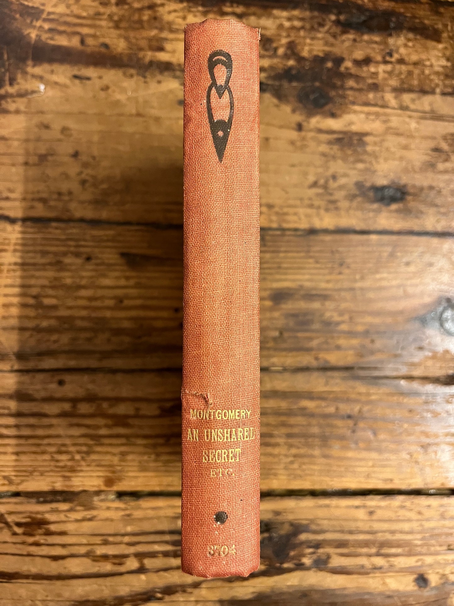 spine of the book "an unshared secret" on a wooden surface