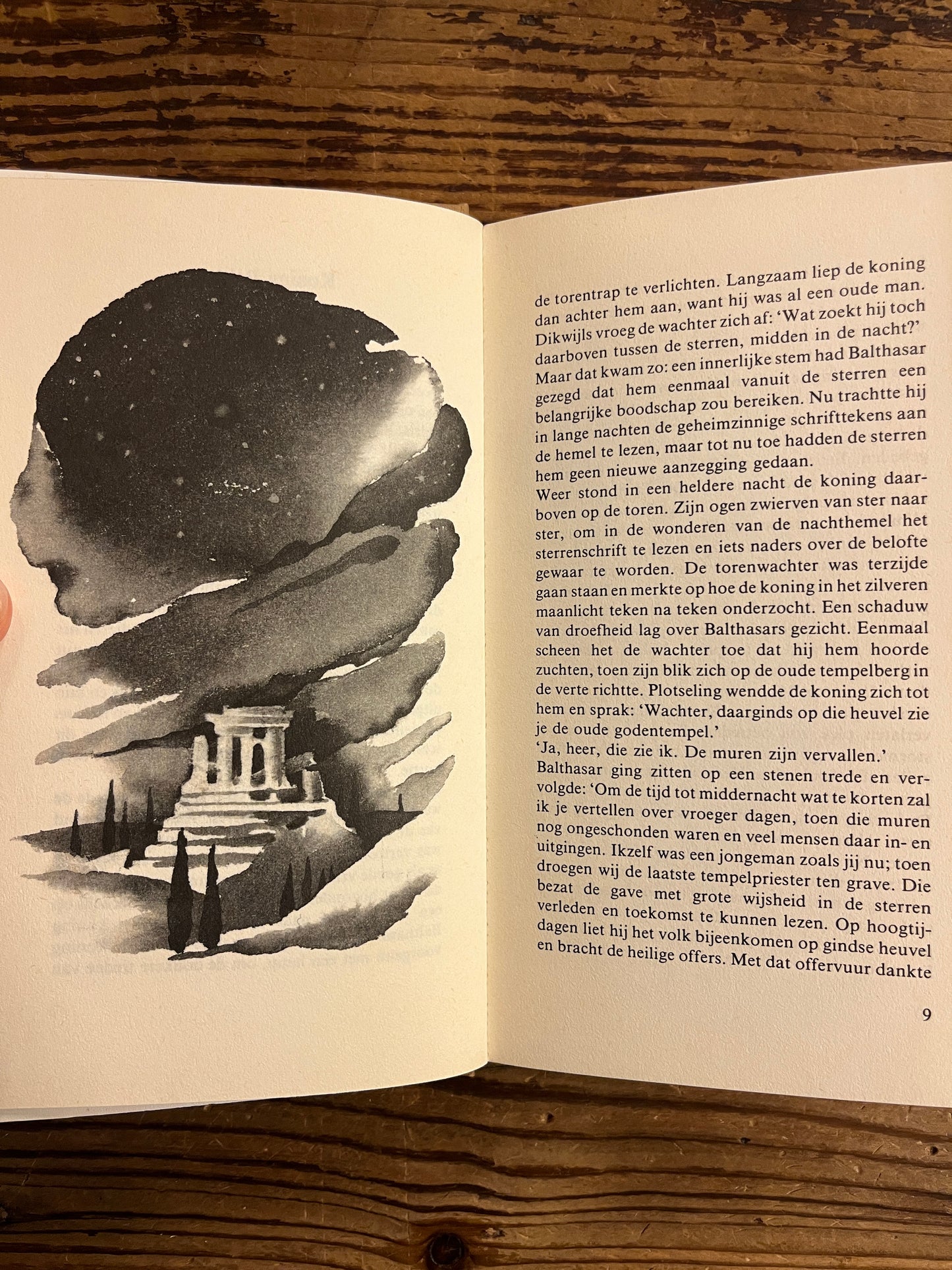 Open boek met de titel 'De wijzen uit het Oosten' door Jakob Streit die tekst en een zwart wit illustratie vertoond op een houten achtergrond 