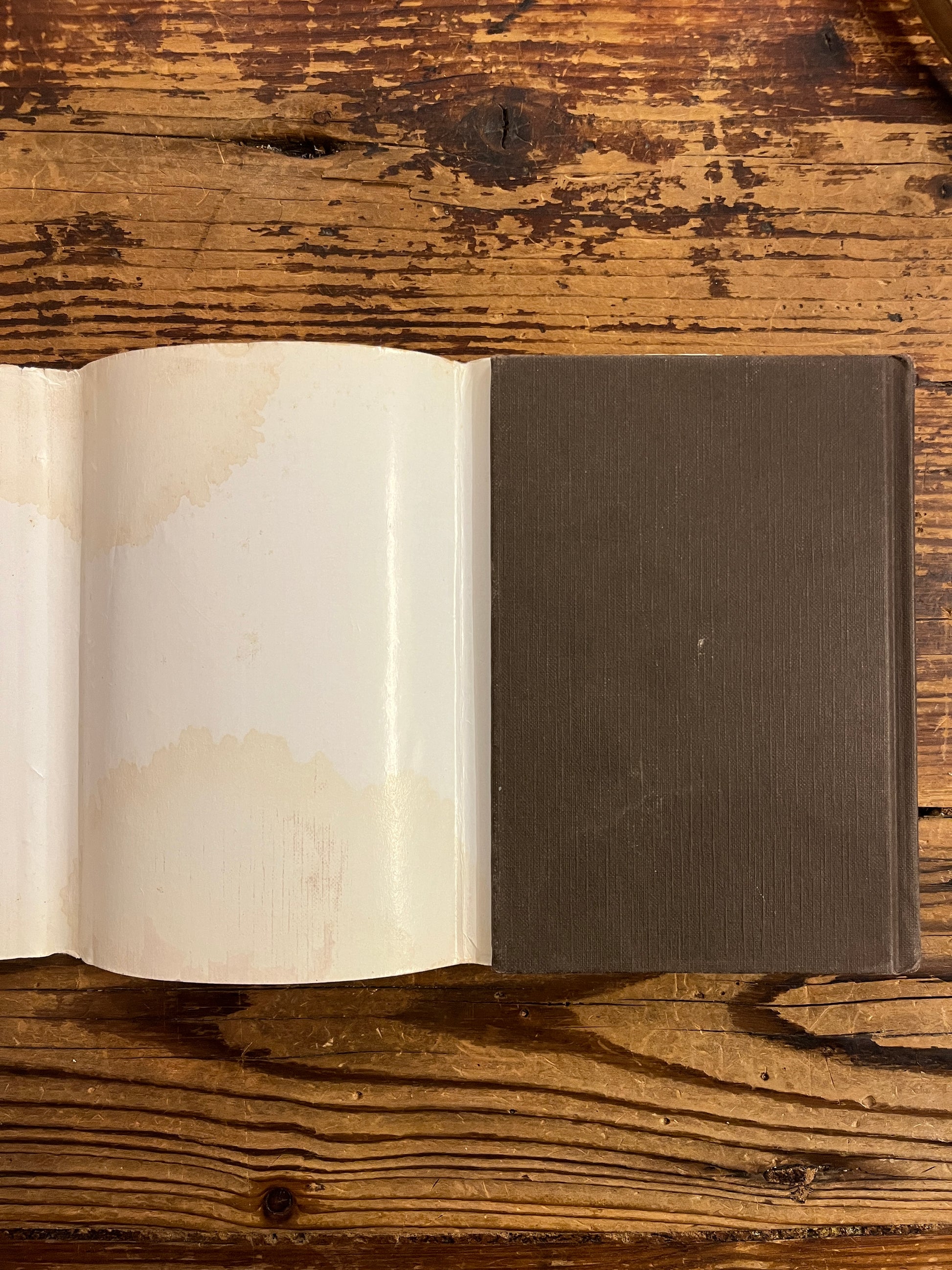 Achter kant zonder stof omslag van Boek met de titel 'leven in overvloed' door Deepak Chopra op een houten achtergrond