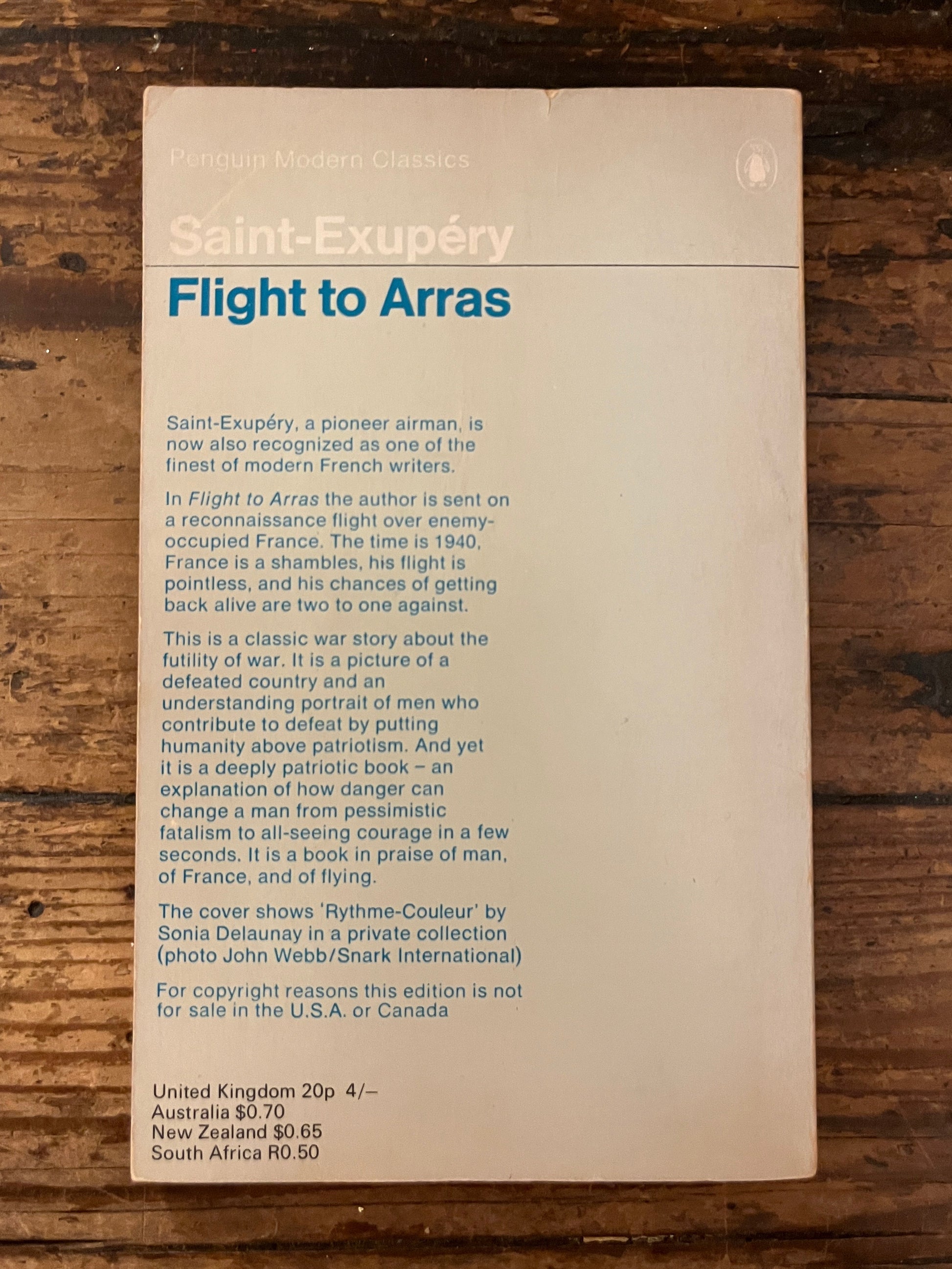back cover of the book "flight to arras"on a wooden background