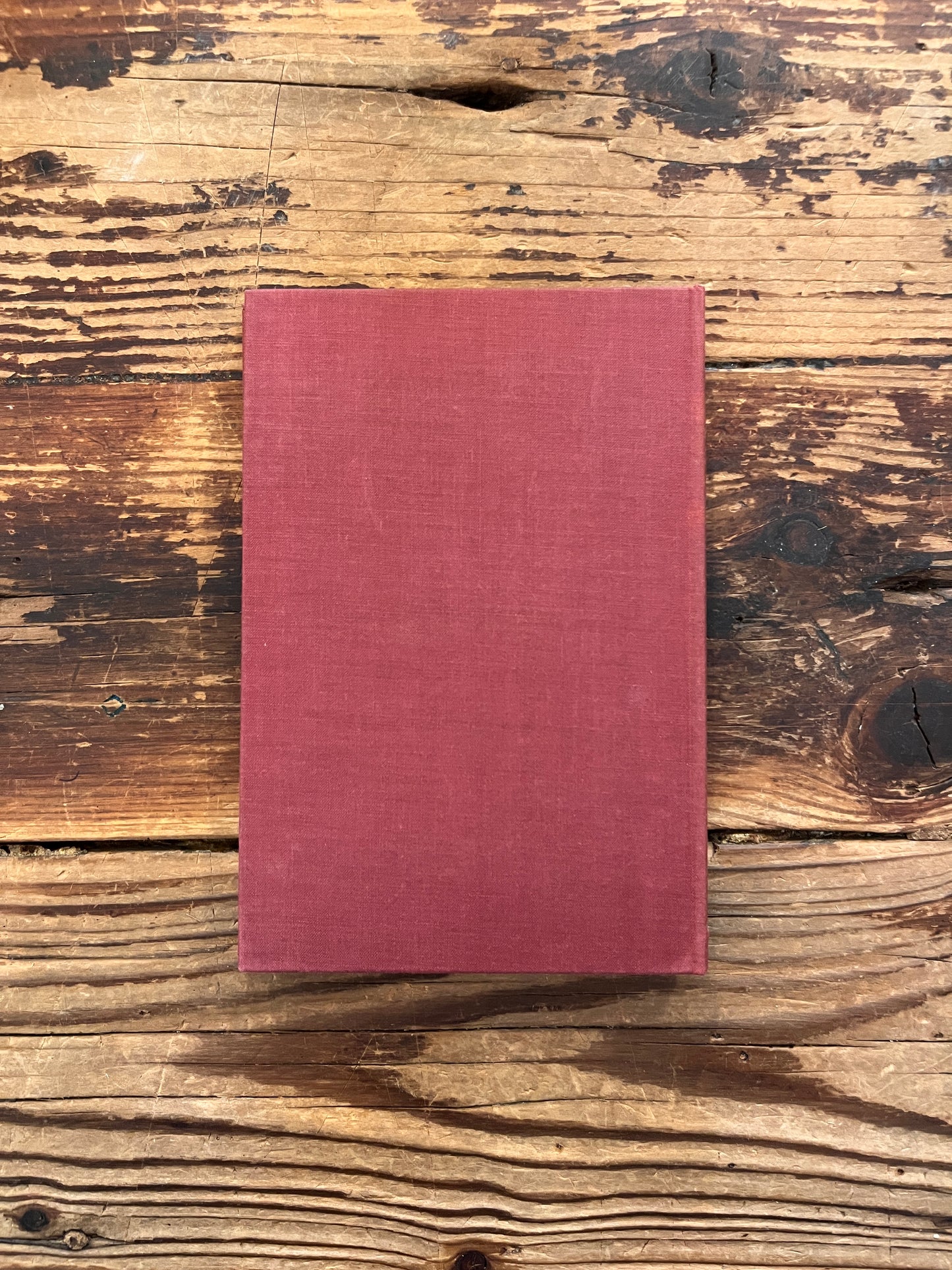 Back cloth cover of a rare book with the title 'practical occultism' by Dion Fortune on a wooden surface 