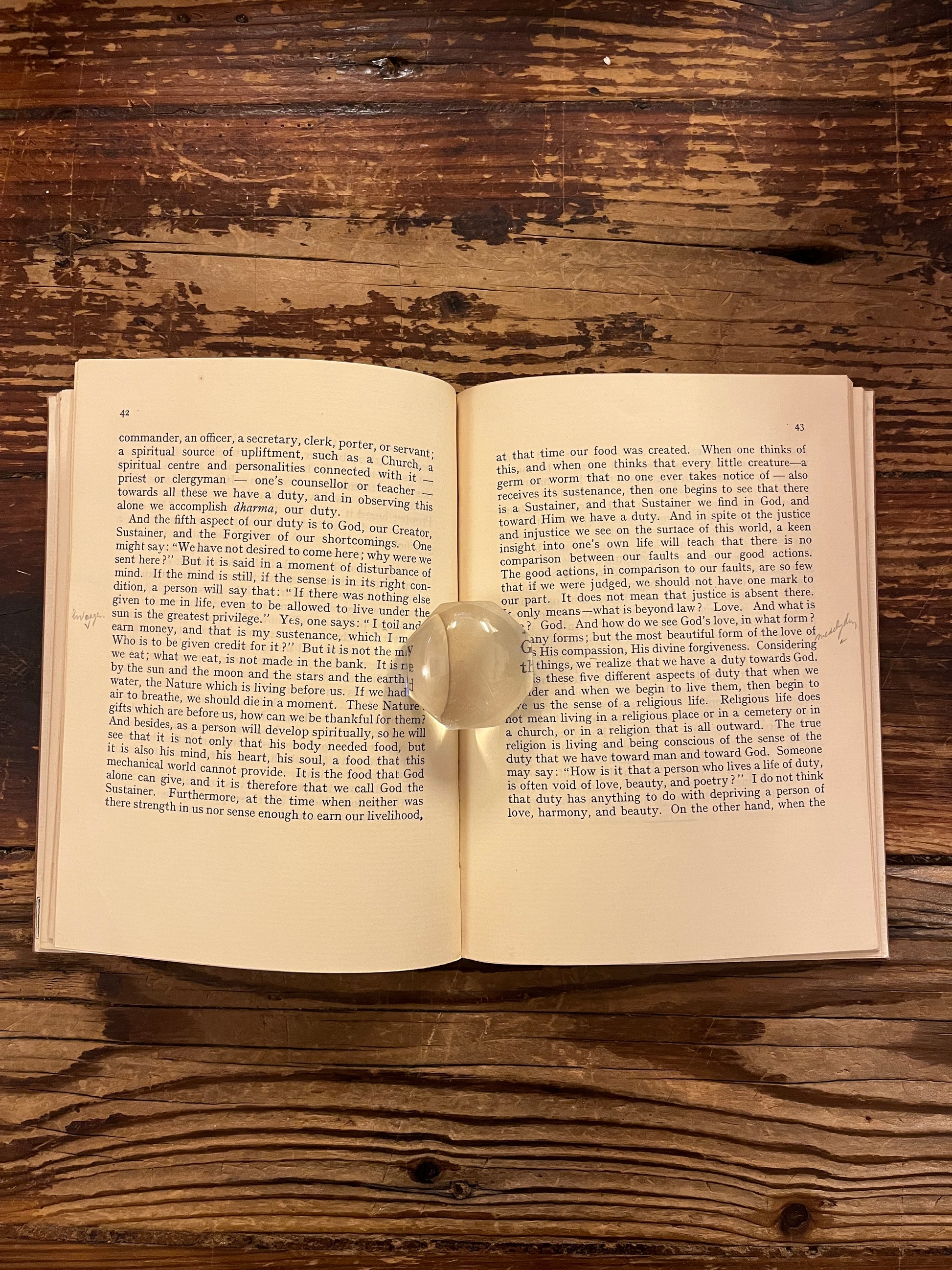 Open book titled 'The Purpose of Life'  by Inayat Khan on a wooden surface