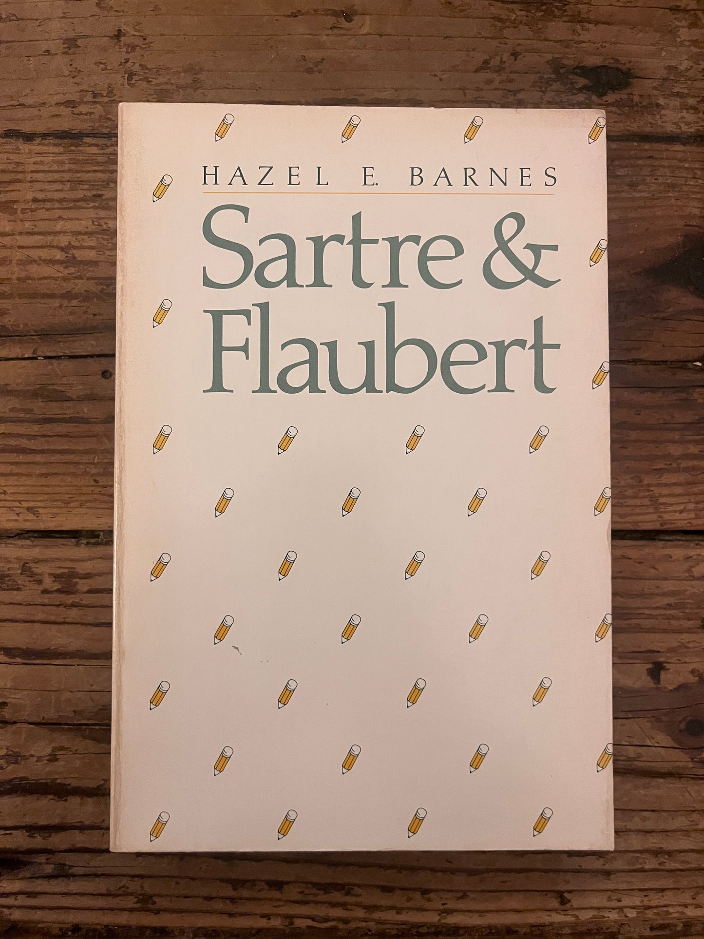 photo of the cover of the book "Sartre & Flaubert" on a wooden background