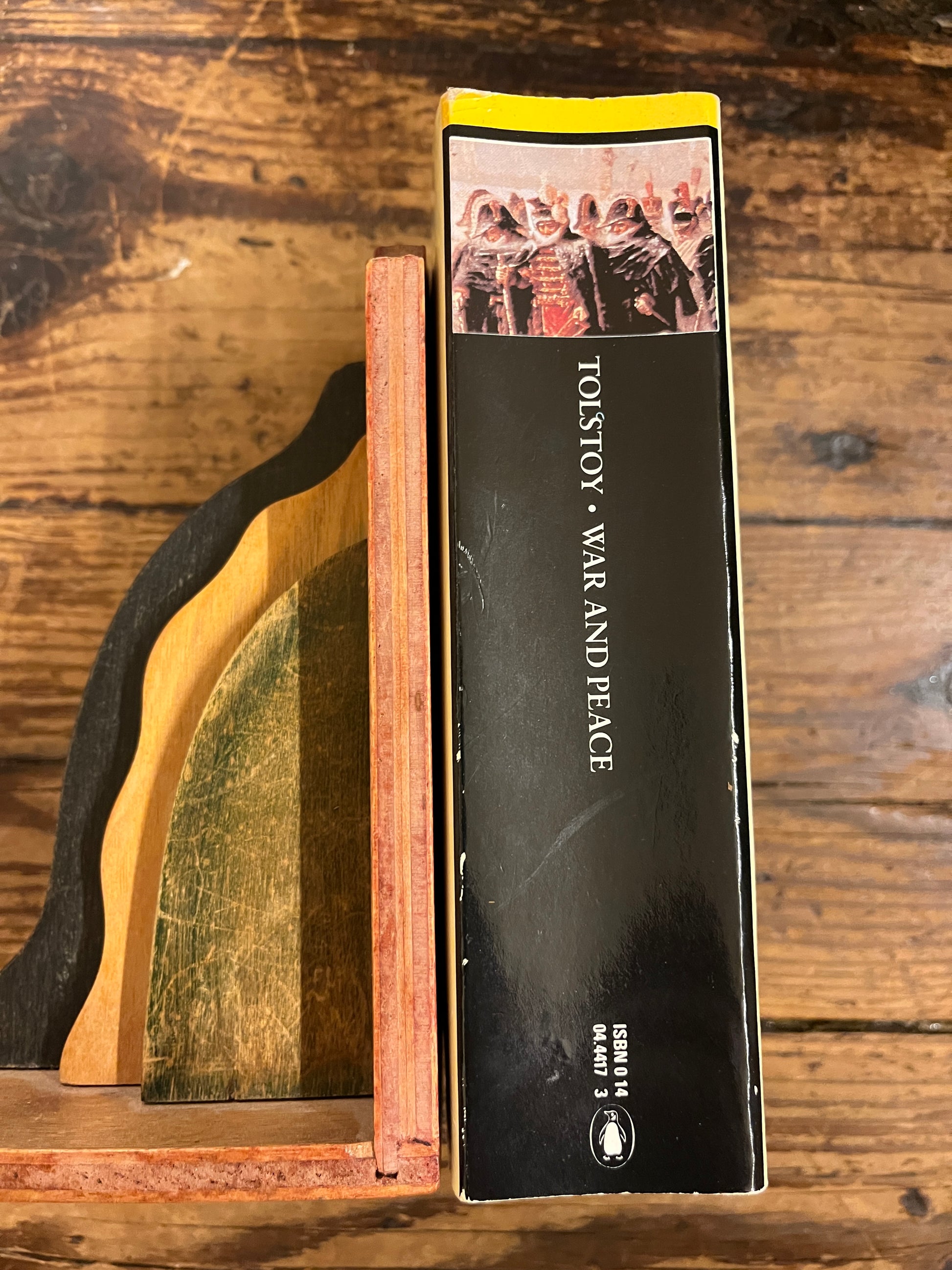 photo of the spine of the book "War and peace" on a wooden background