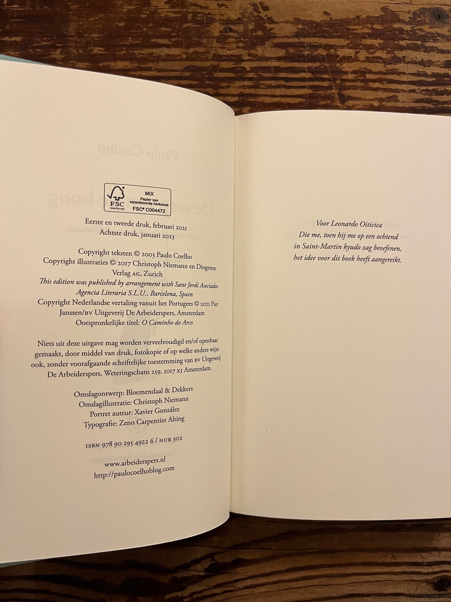 Open boek 'de weg van de boog' door Paulo Coelho op een houten achtergrond 