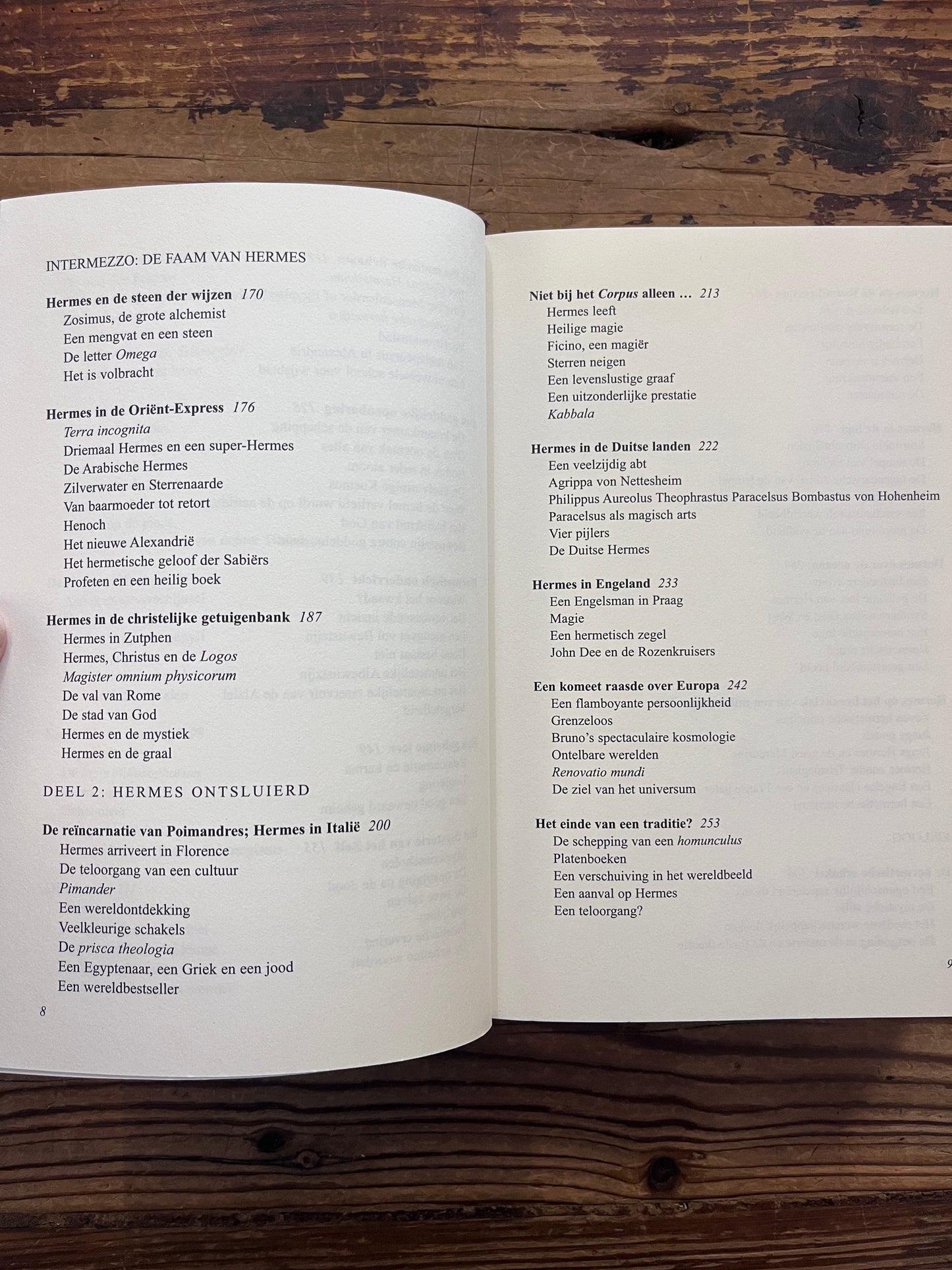 Open boek met de titel 'de Hermetische Schakel' door Jacob Slavenburg op een houten achtergrond 
