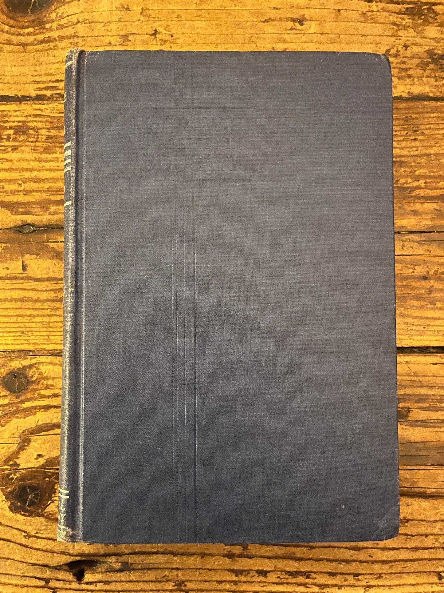 photo of the cover of the book "modern philosophies of educatio" on a wooden background