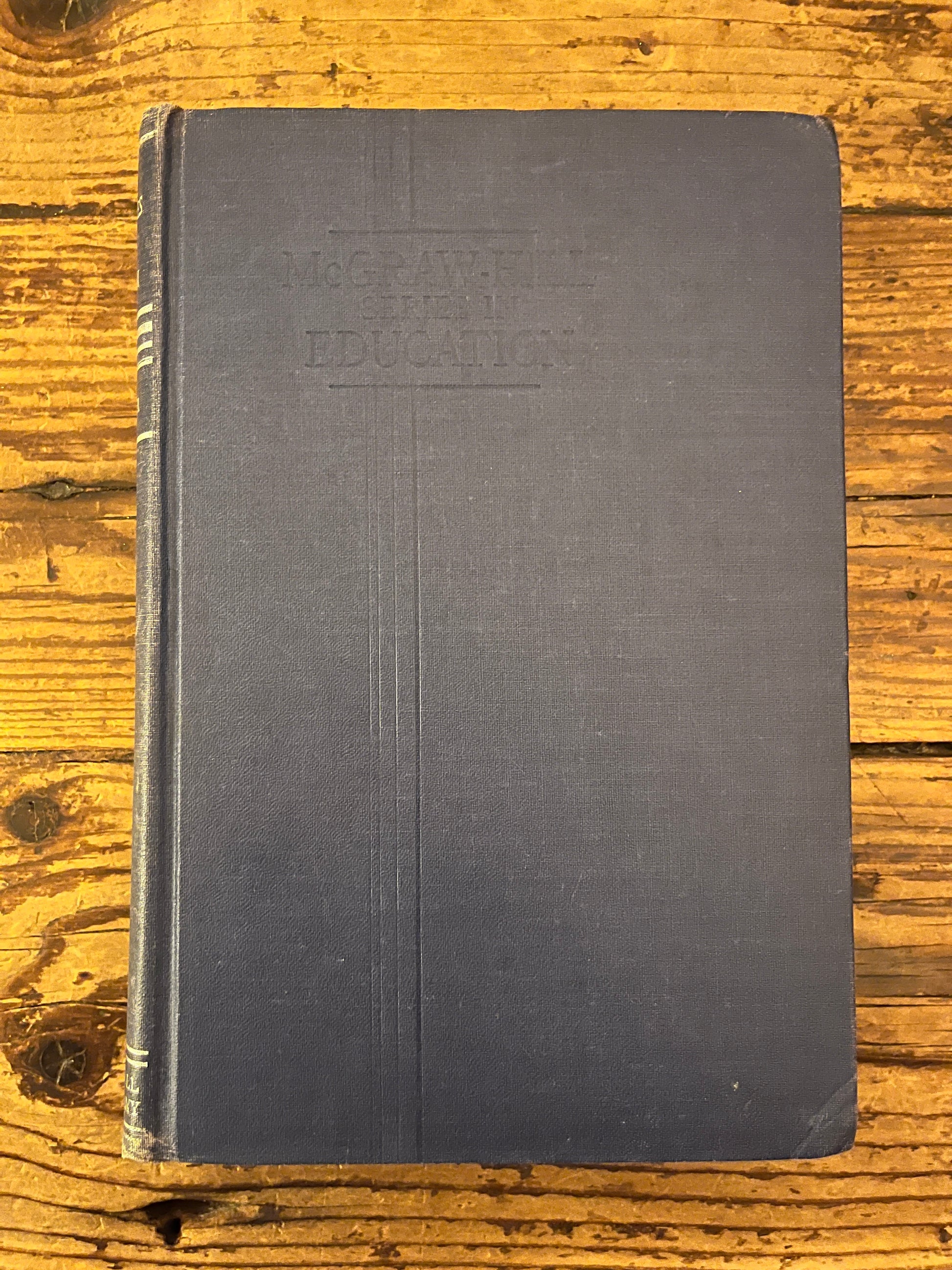 photo of the cover of the book "modern philosophies of educatio" on a wooden background