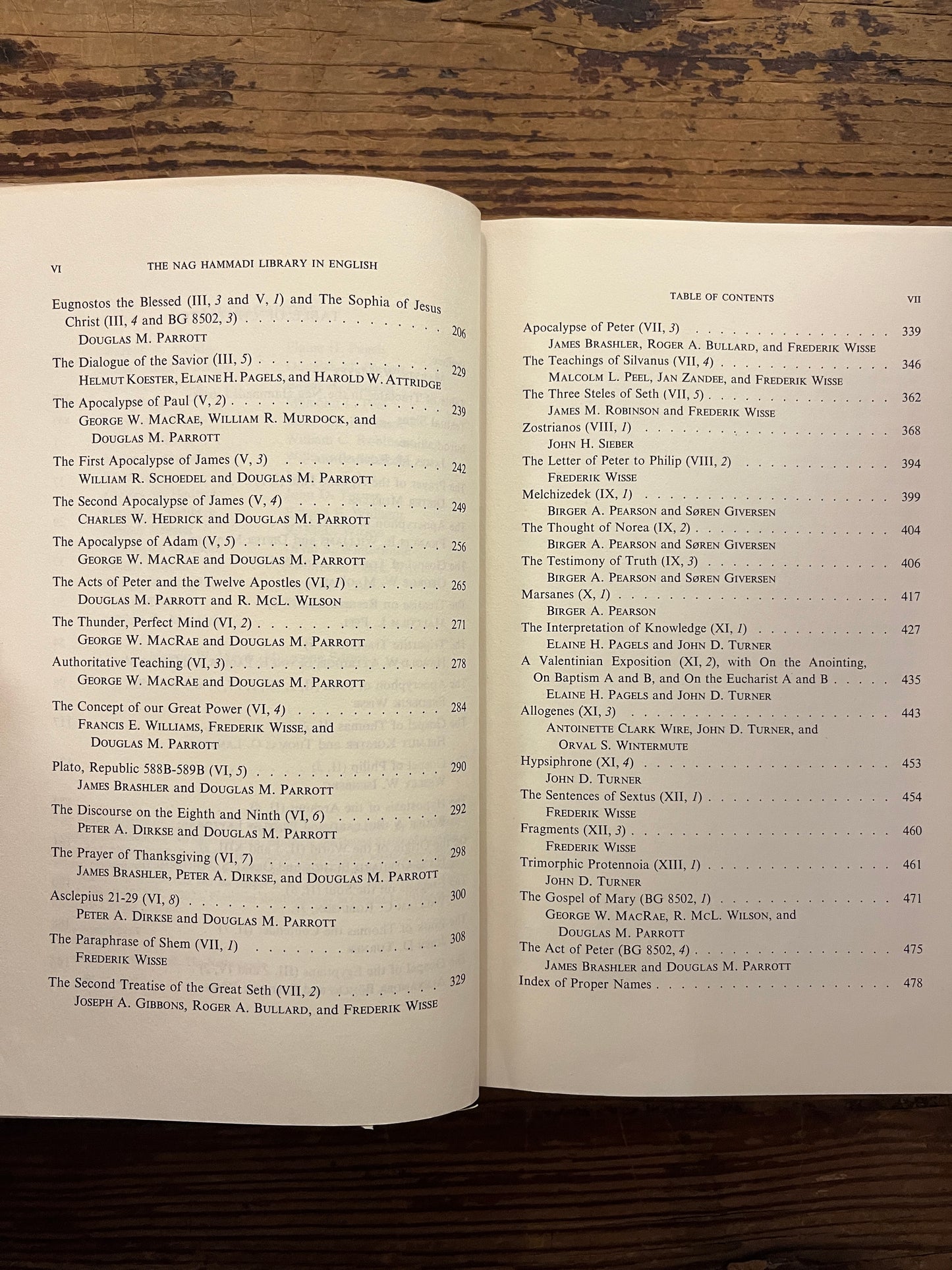 Open book titled 'The Nag Hammadi Library in English' on a wooden surface