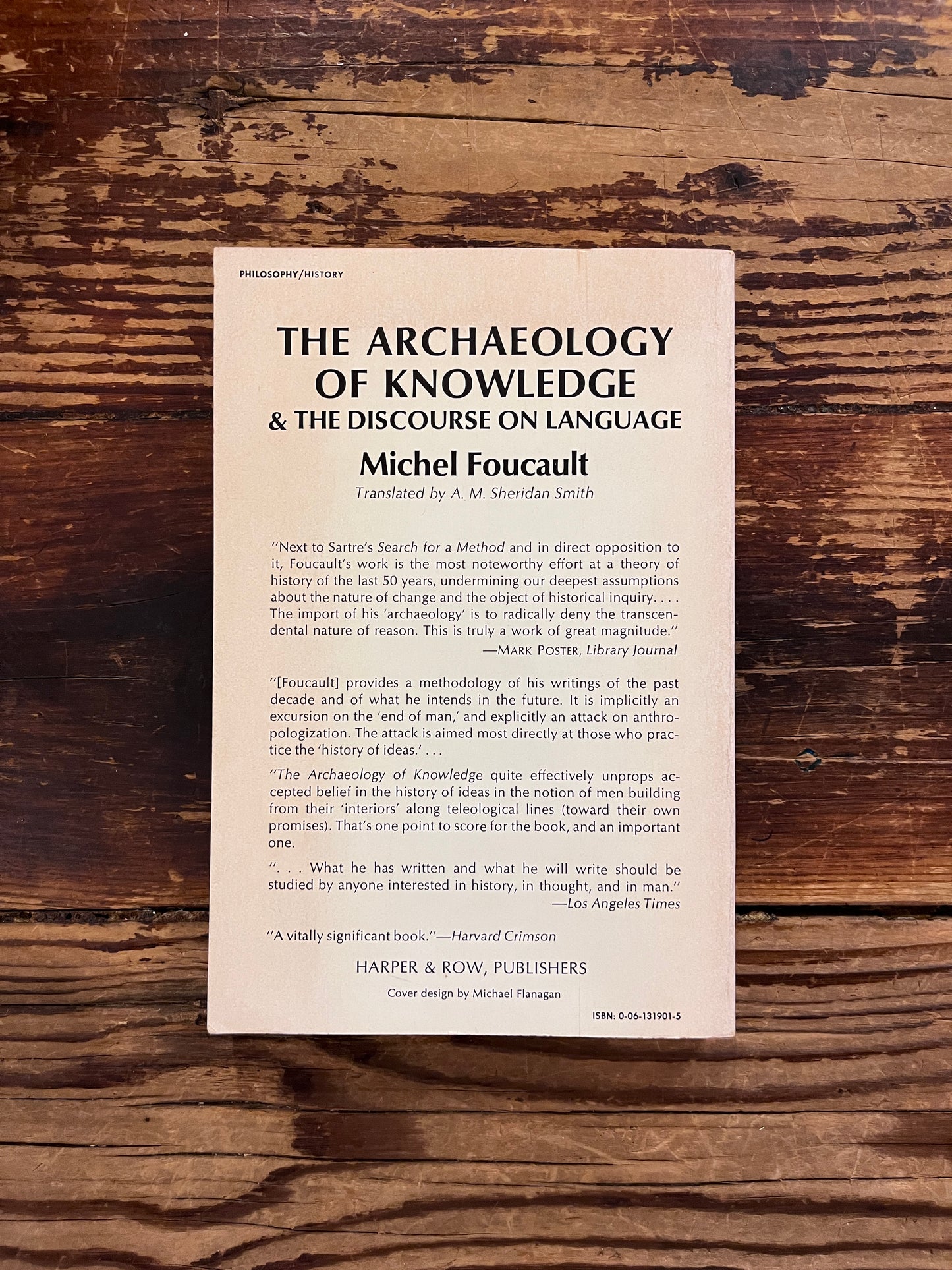 photo of the cover of the book "the archaeology of knowledge" on a wooden background
