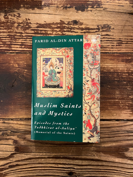 Book titled 'Muslim Saints and Mystics' by Farid al-Din Attar on a wooden surface