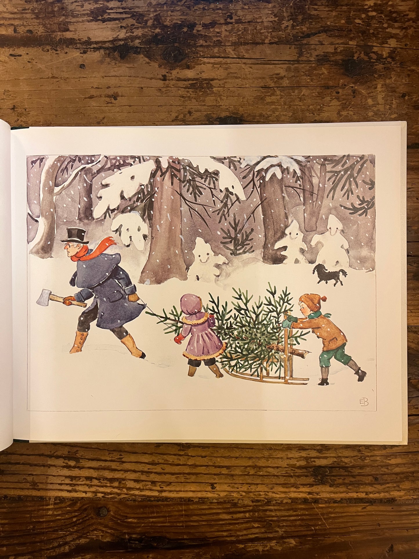 inzicht van een afbeeling uit het boek "peter en lotta vieren kerstfeest" op een houten achtergrond