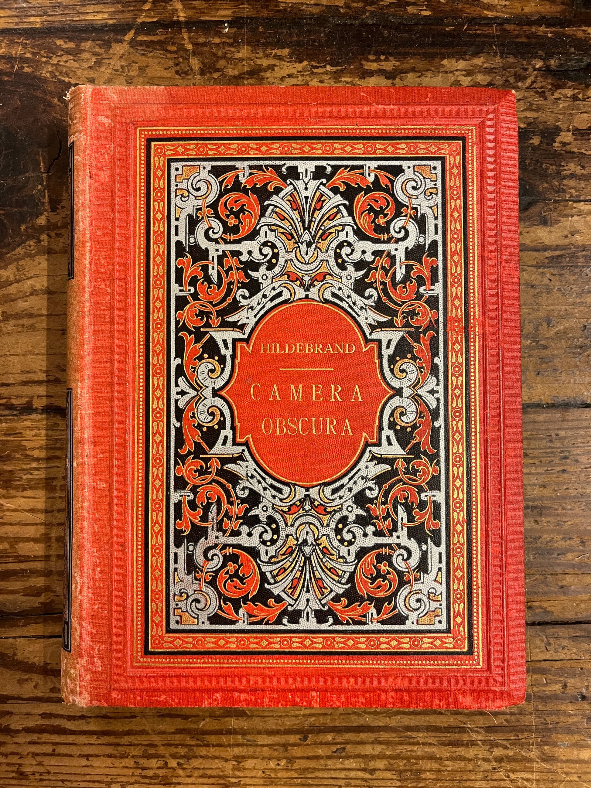 boekomslag van het boek "camera obscura" op houten achtergrond