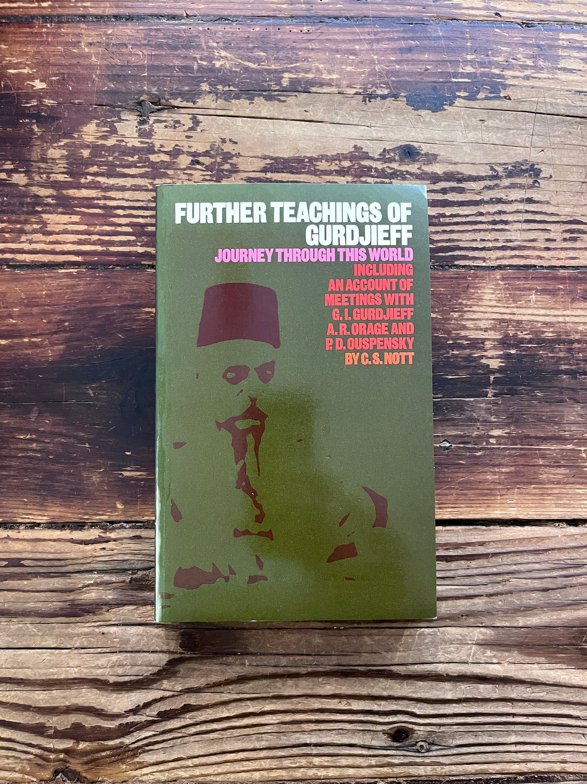 Front cover of book titled 'Further Teachings of Gurdjieff' by C.S. Nott with an olive green cover, placed on a rustic dark wood background.