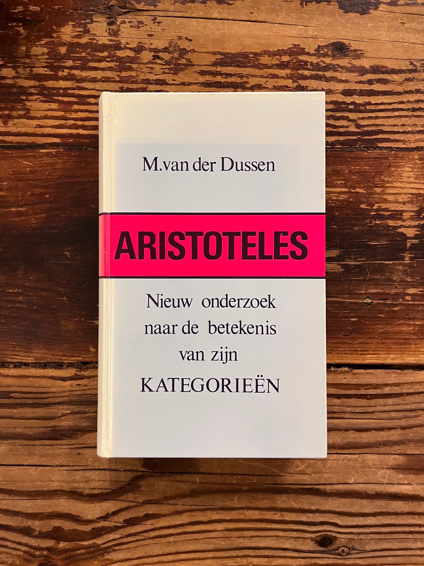 foto van de omslag van het boek " Aristoteles nieuw onderziek naar de betekenis van zijn categorieen" op houten achtergrond