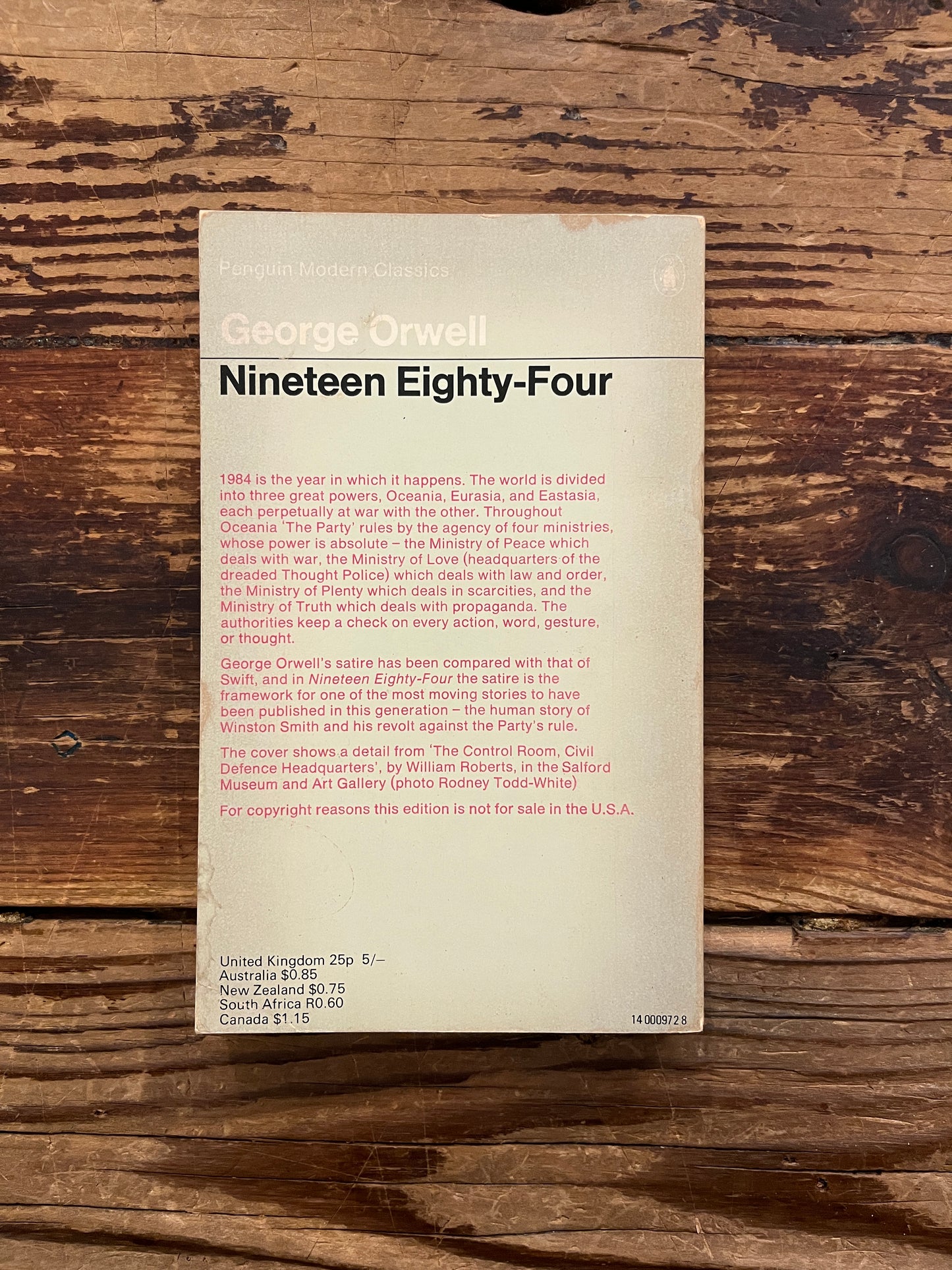 Back cover  book titled 'Nineteen Eighty-Four' by George Orwell on a wooden surface