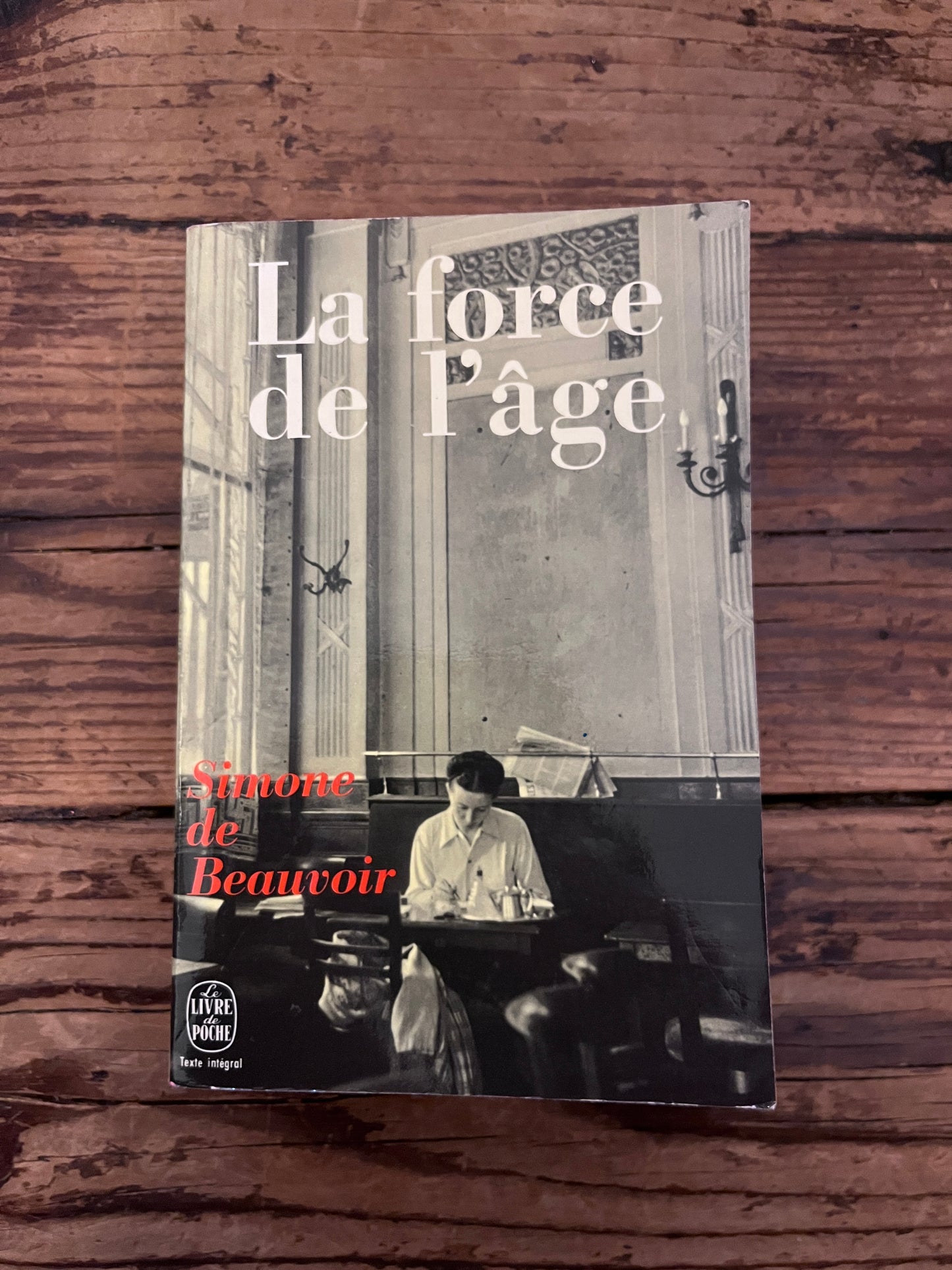photo de la couverture du livre "la force de l'âge" sur fond de bois 