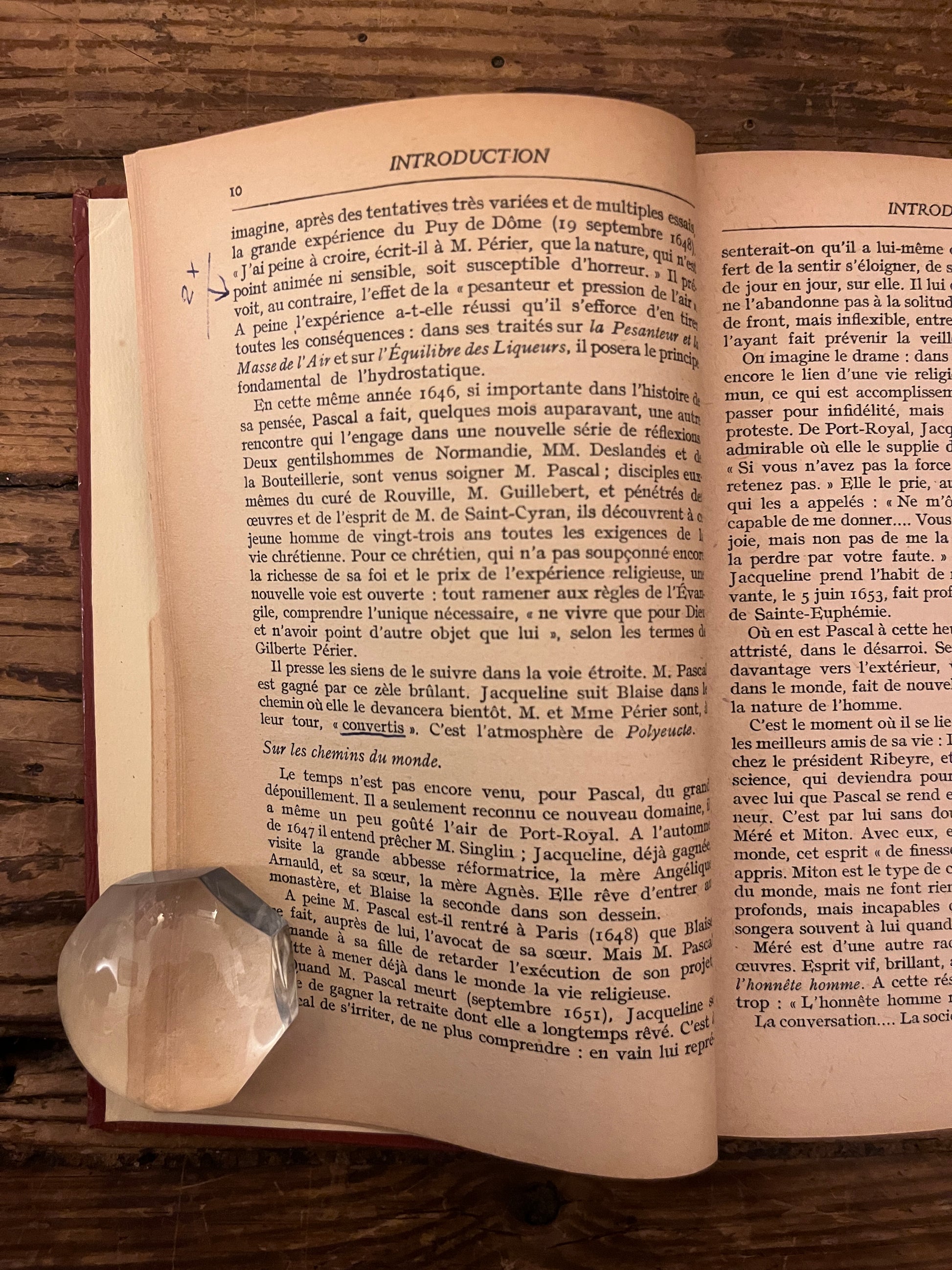 photo d'une page du livre "pensees" sur fond de bois. On y vot qu'un mot y est souligne.