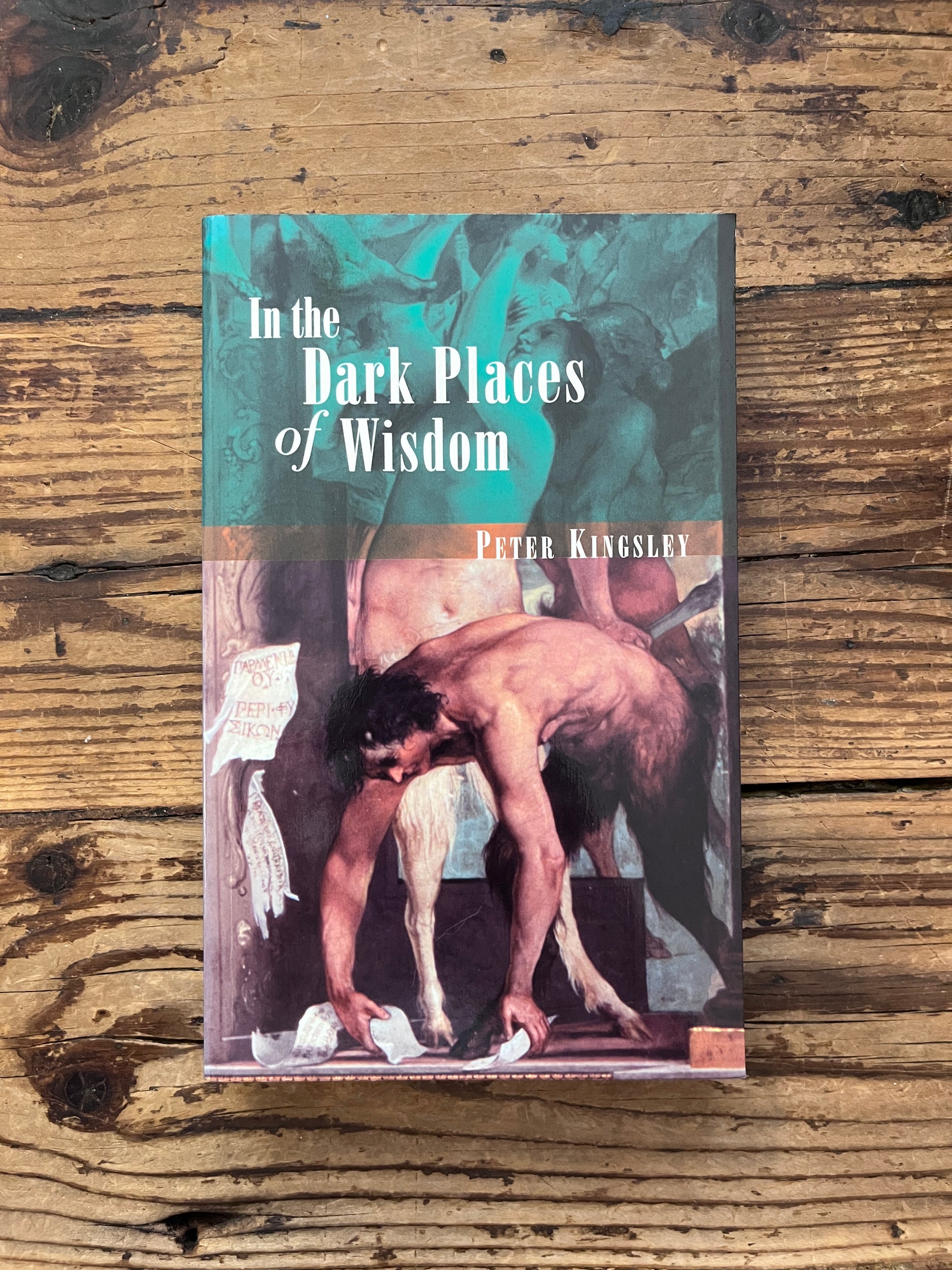 photo of the cover of the book "dark places of wisdom" on a wooden background