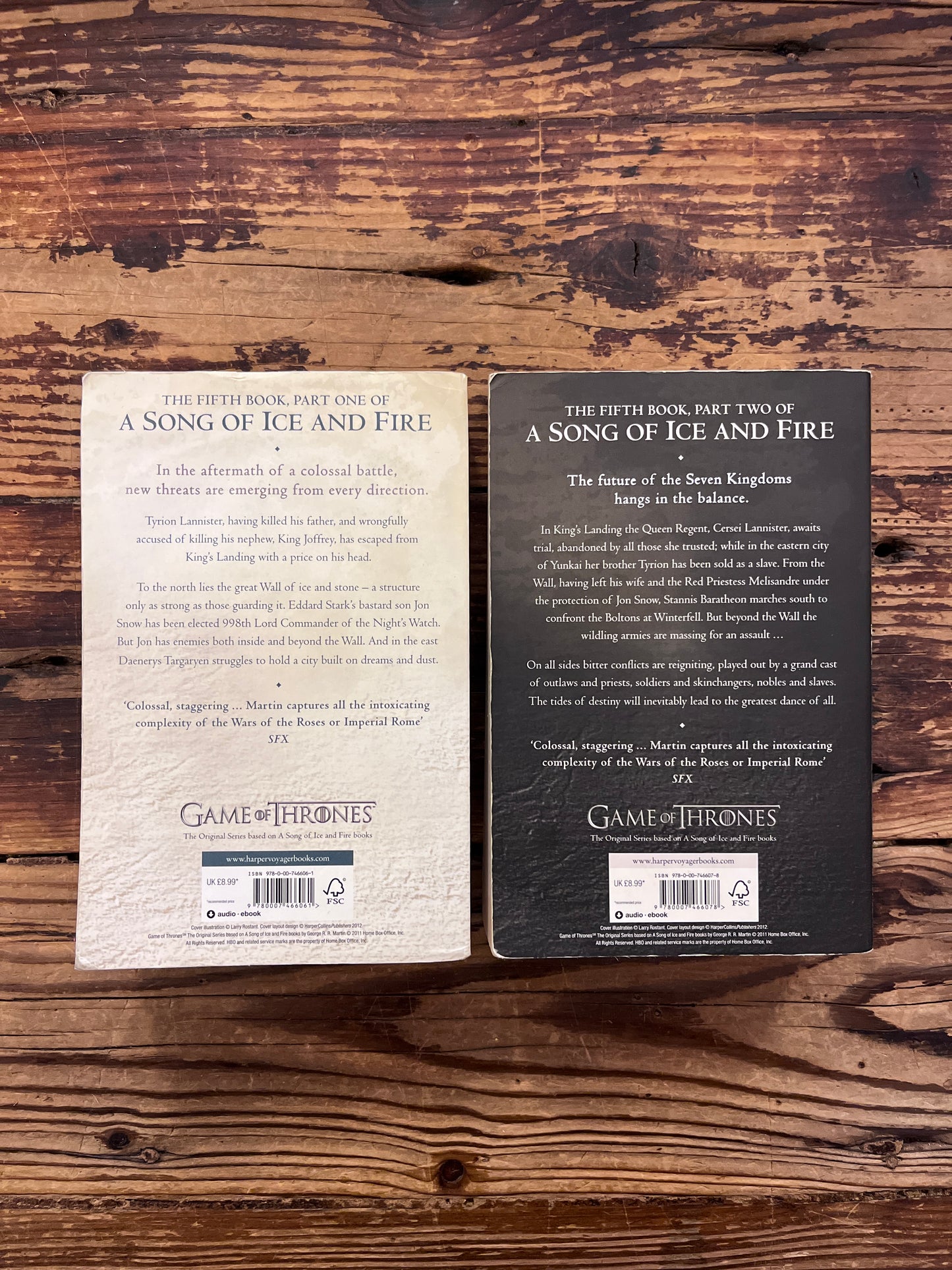 Two books titled 'A Dance with Dragons' by George R.R. Martin on a wooden surface.