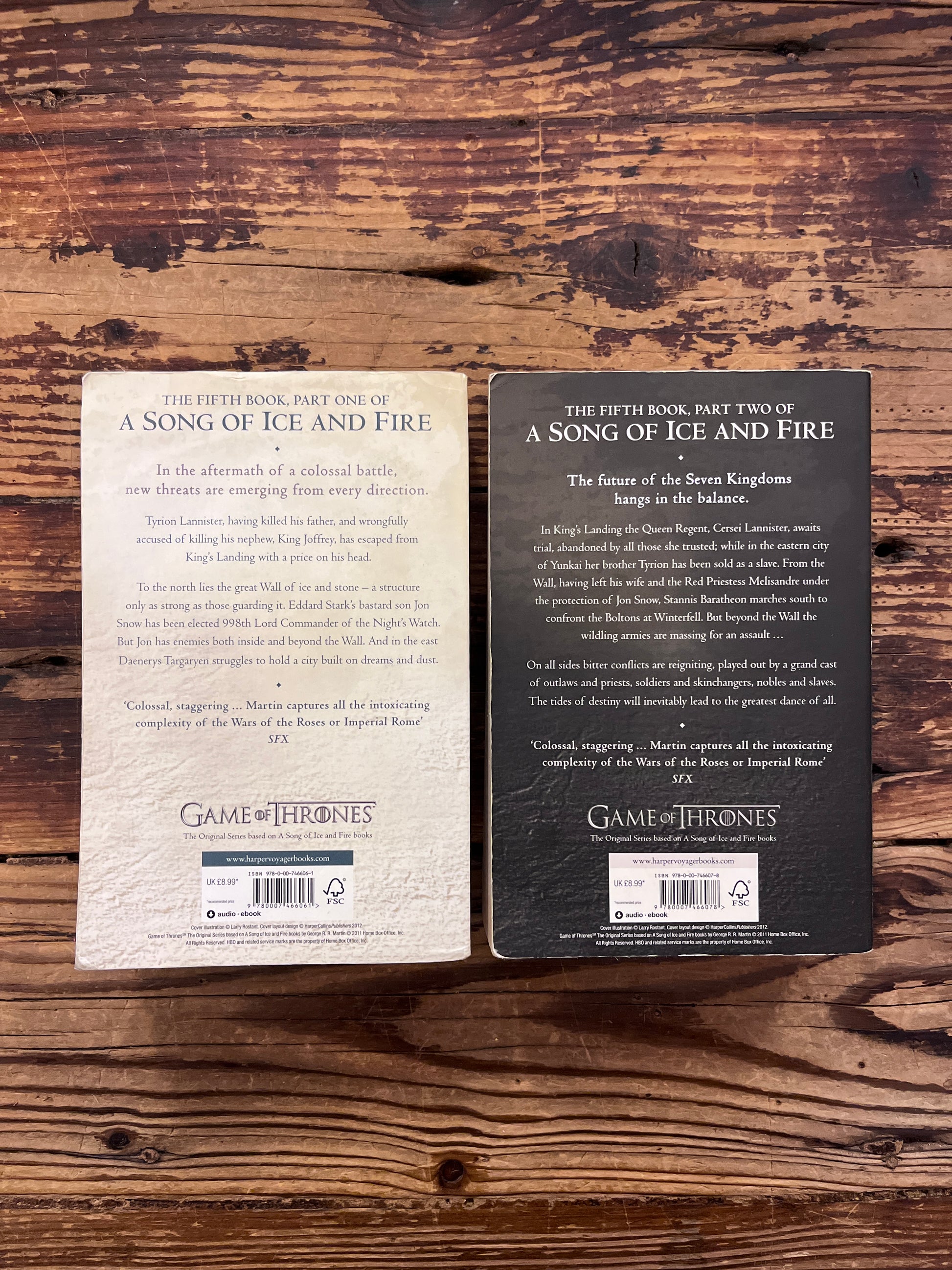 Two books titled 'A Dance with Dragons' by George R.R. Martin on a wooden surface.