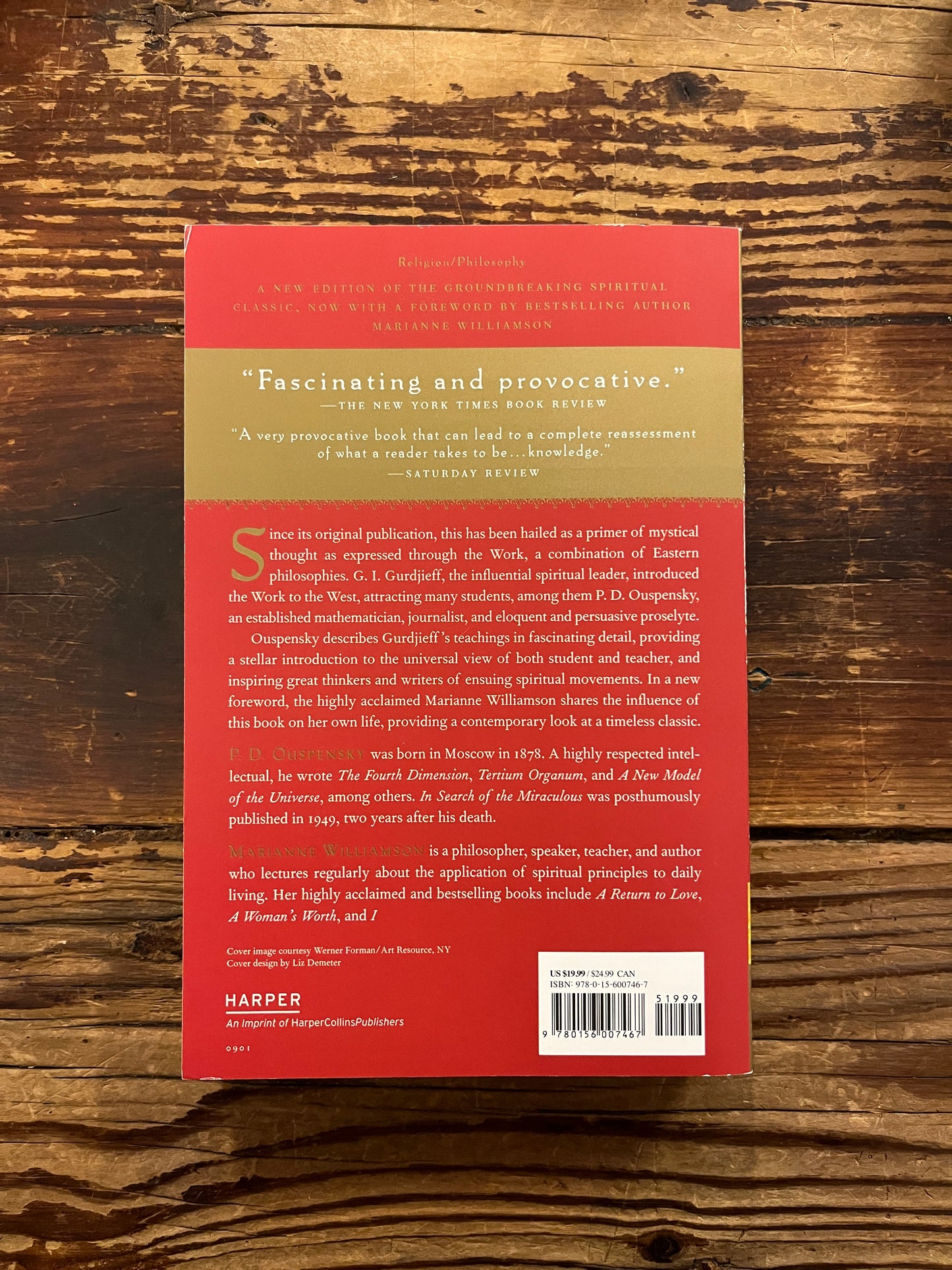 Back cover of book titled 'In Search of the Miraculous' by P.D. Ouspensky on a wooden surface