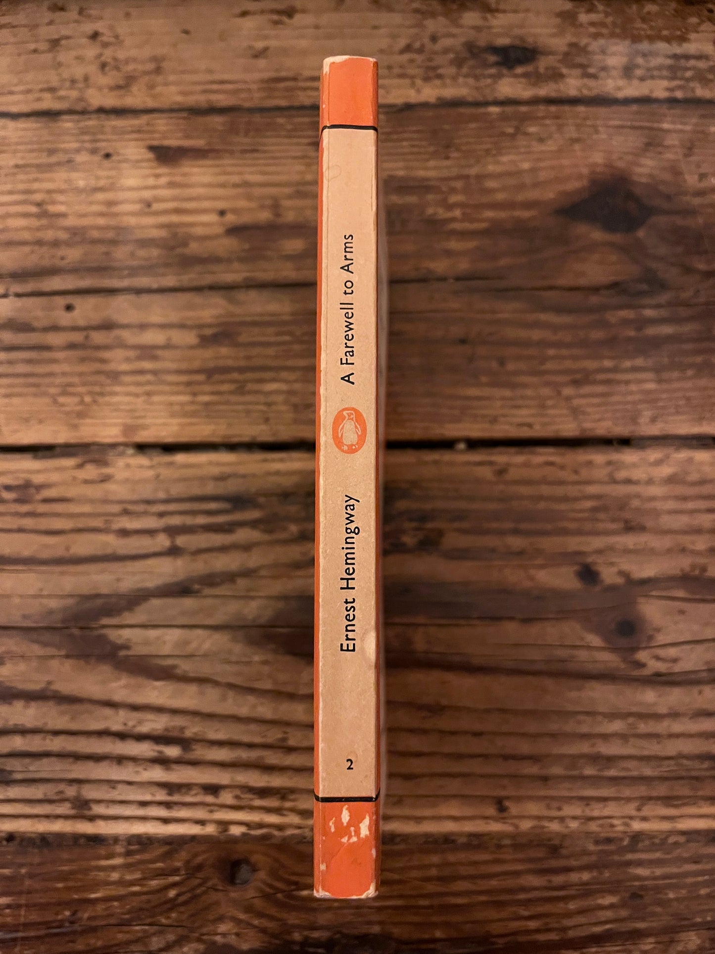 pictures of the spine of the book "a farewell to arms" on a wooden background