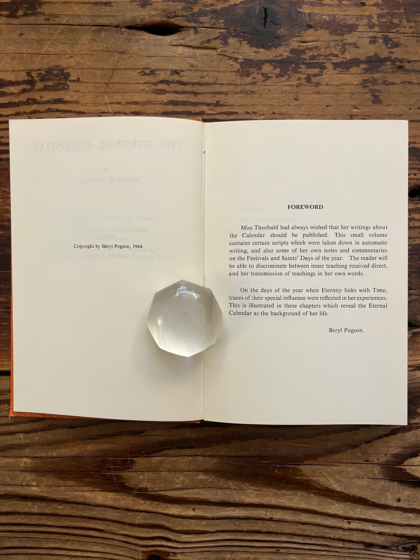 Open book with the tile 'the eternal calendar' by Minnie Theobald on a wooden surface