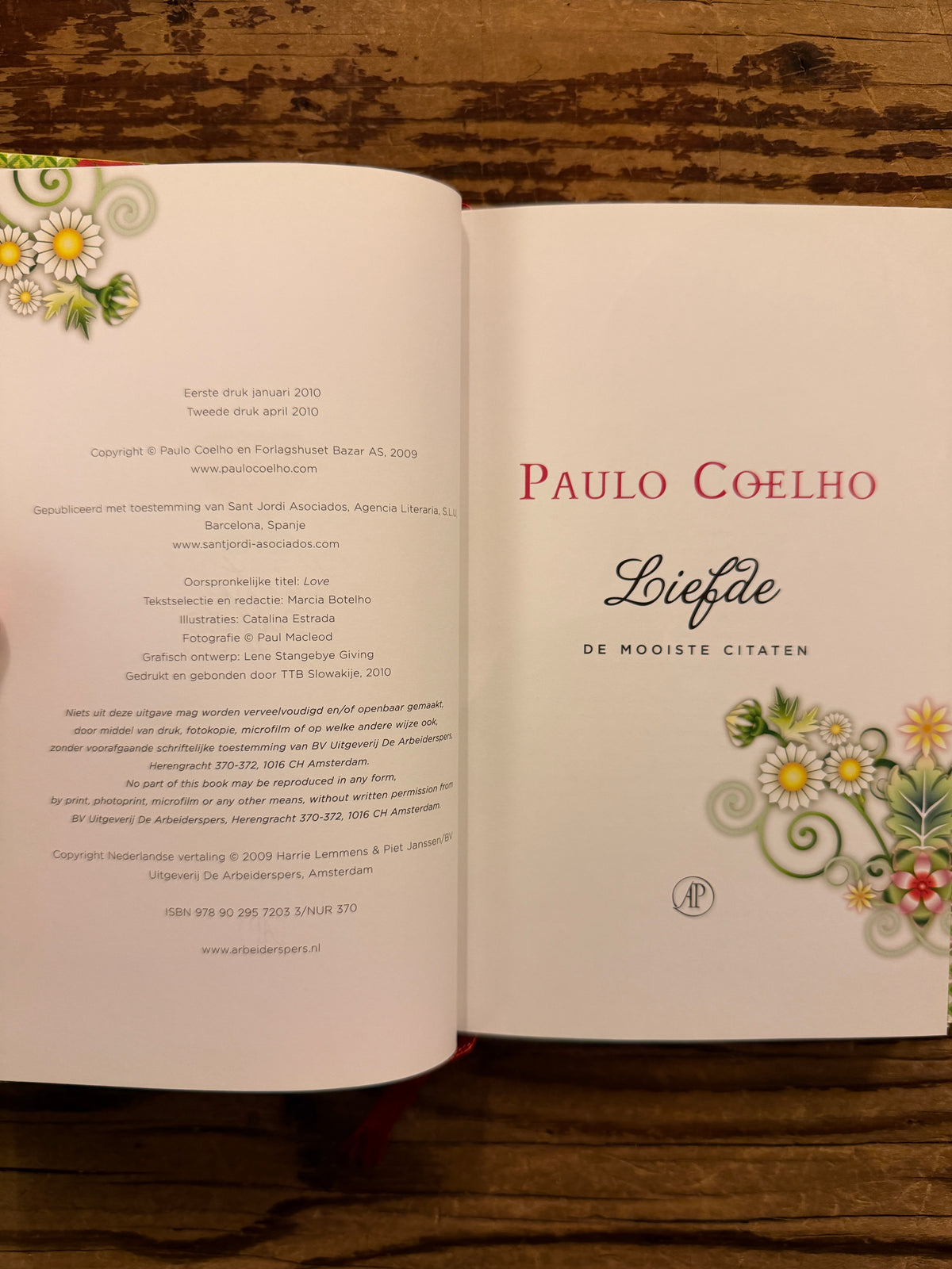 Open boek met de titel 'liefde' door Paulo Coelho op een houten achtergrond