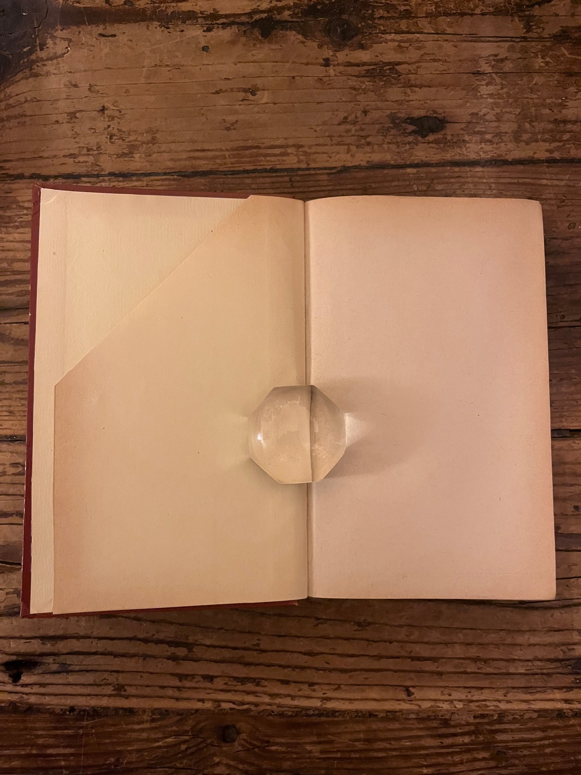 photo de la première page du livre "pensees" sur fond de bois On y voit que celle ci est coupée en diagonale