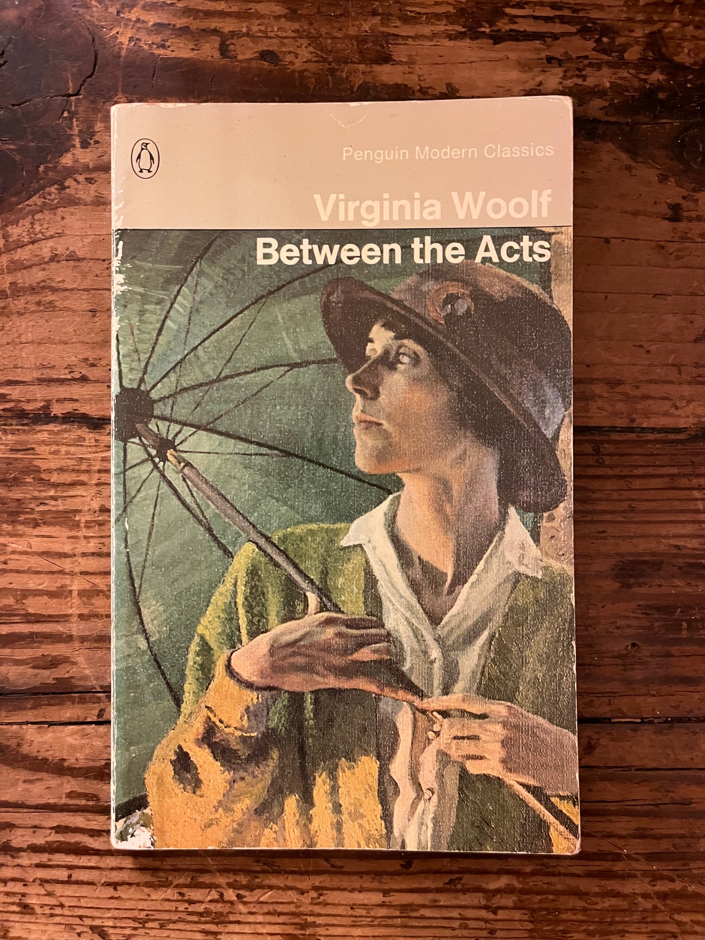 photo of the front cover of the book "between the acts" on a wooden background
