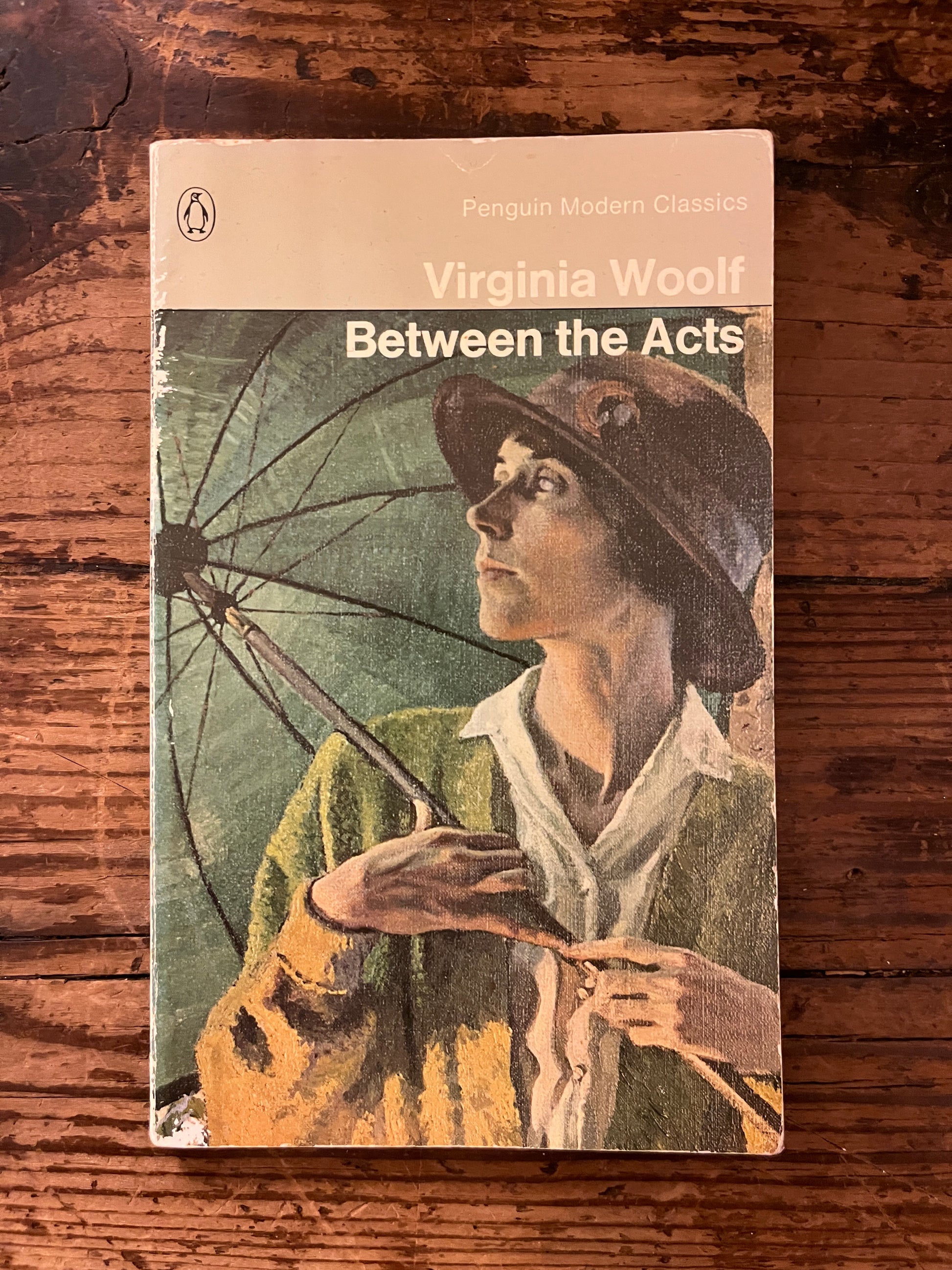 photo of the front cover of the book "between the acts" on a wooden background