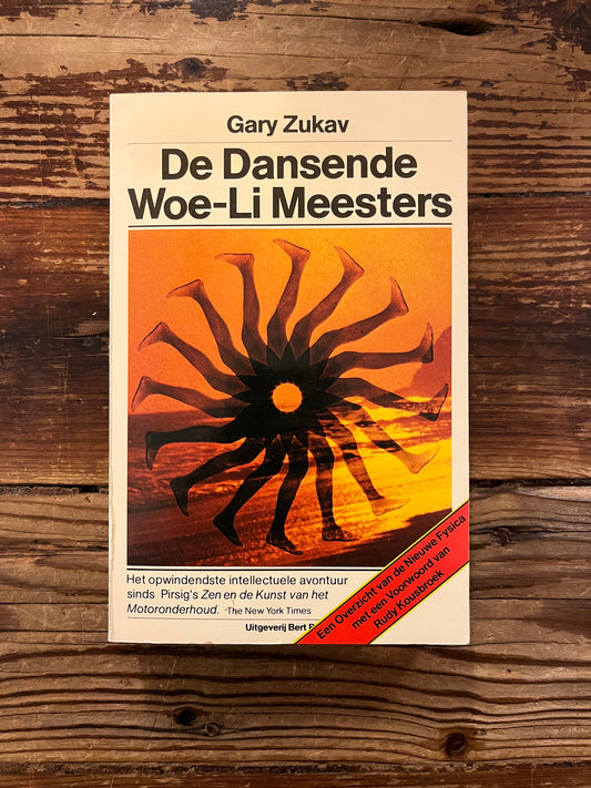 Boek met de titel 'De Dansende Woe-Li Meesters' door Gary Zukav op een houten achtergrond
