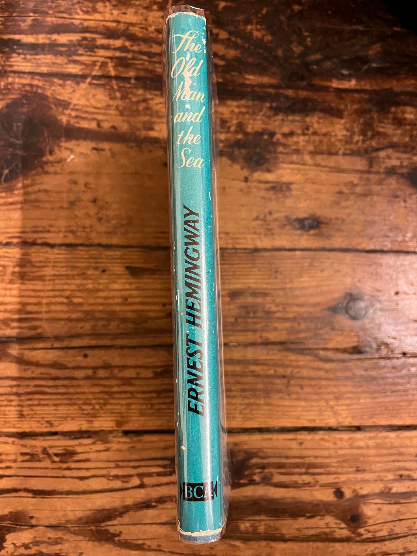 photot of the spine of the book "The old man and the sea"on a wooden background