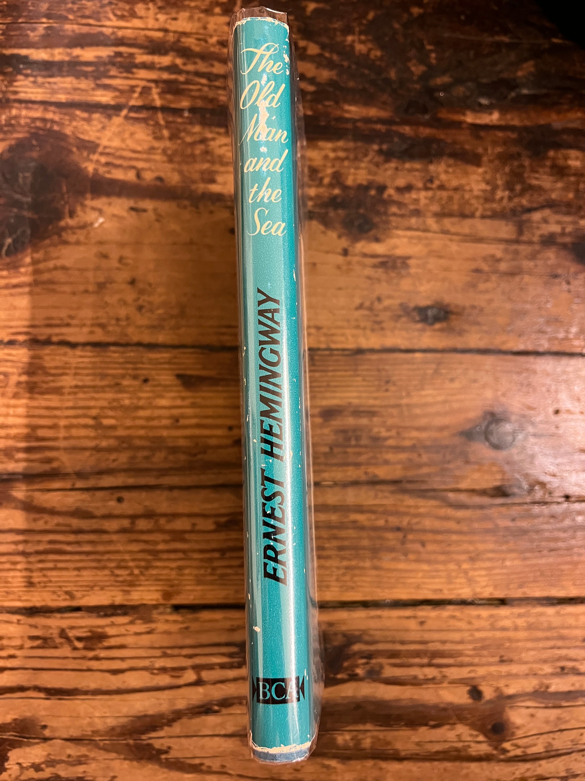 photot of the spine of the book "The old man and the sea"on a wooden background