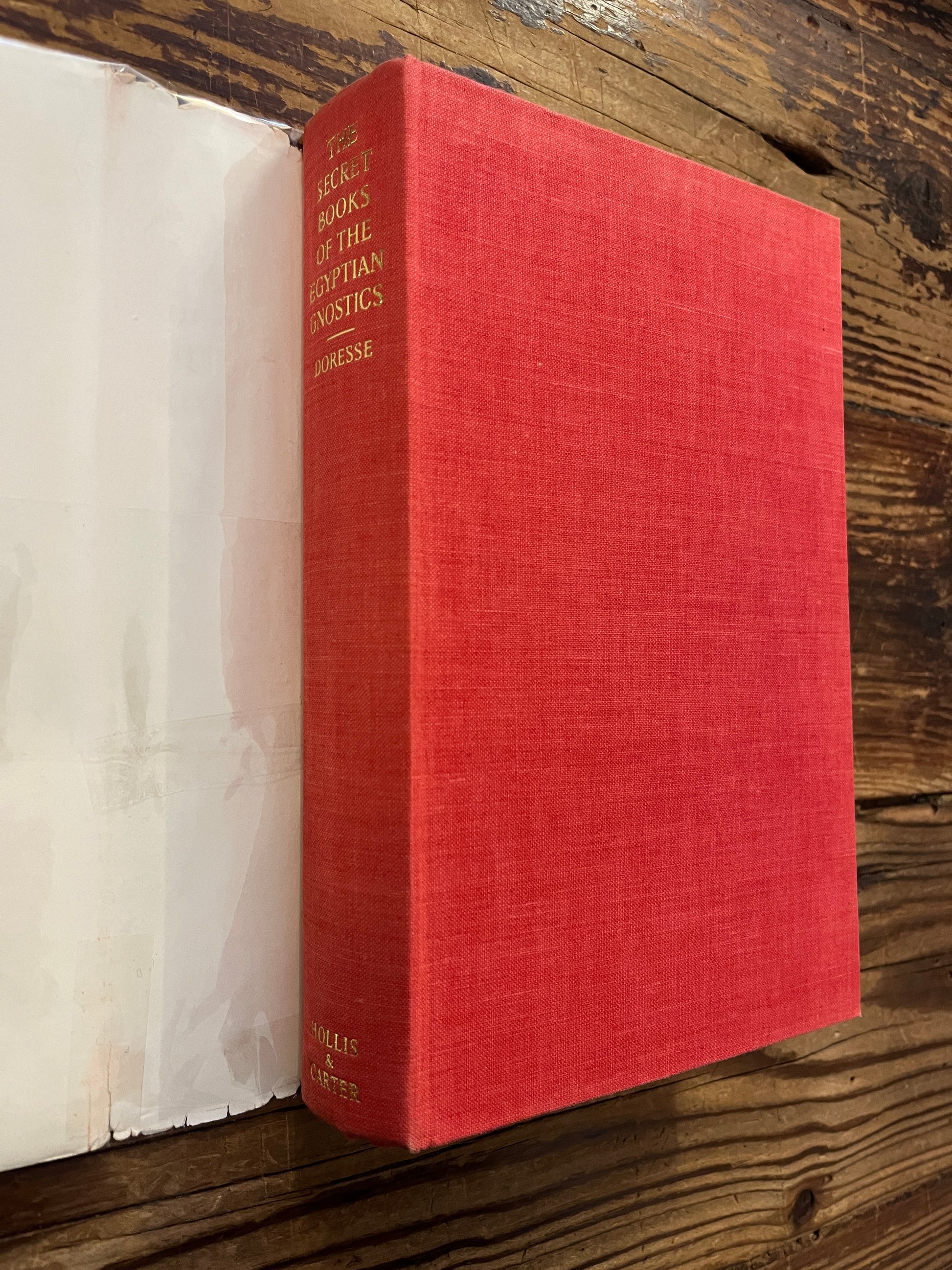 Book titled 'The Secret Books of the Egyptian Gnostics' by Jean Doresse on a wooden surface