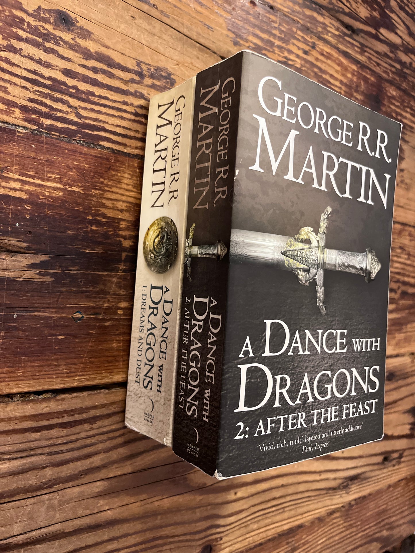 Two books titled 'A Dance with Dragons' by George R.R. Martin on a wooden surface.