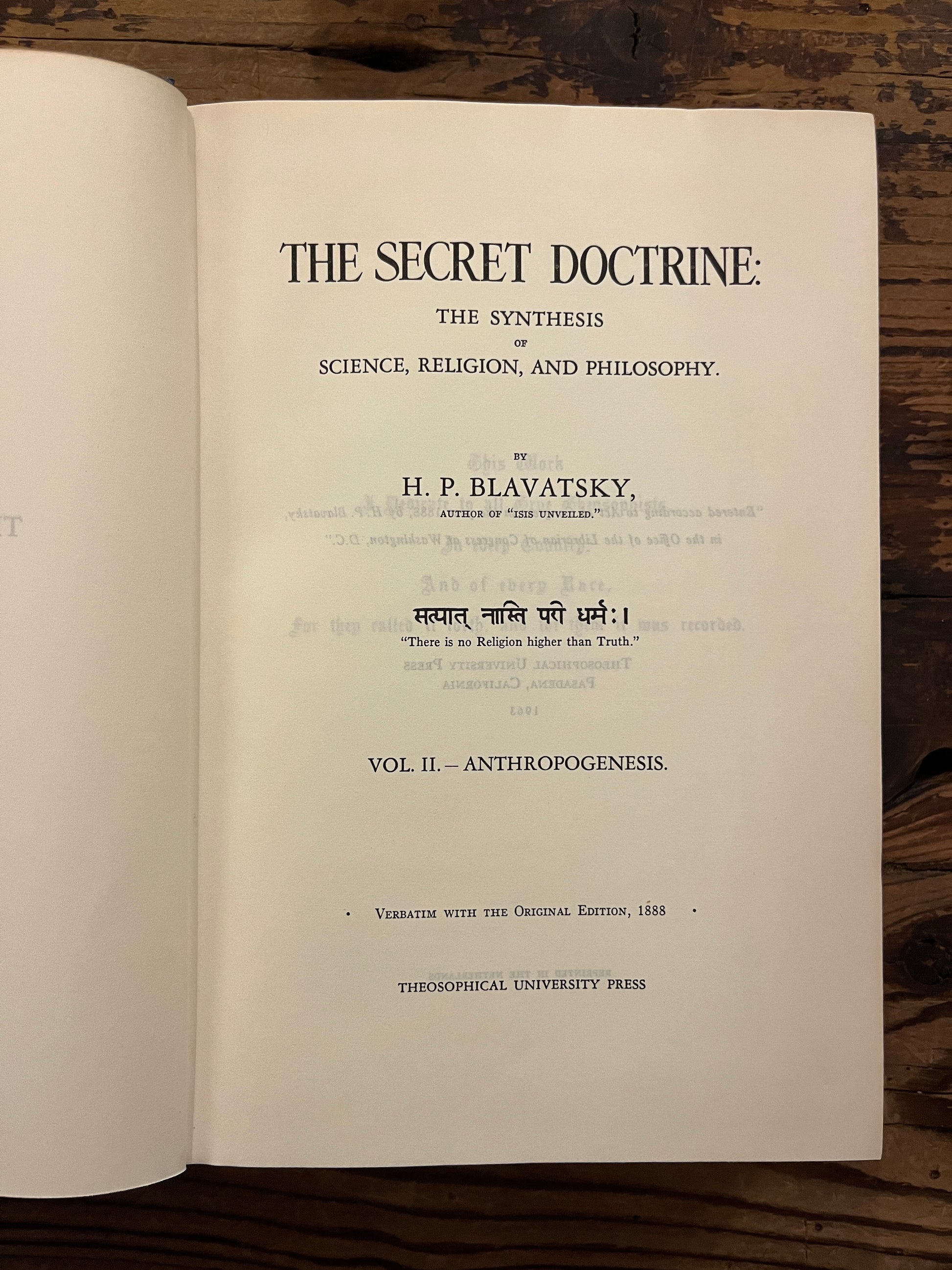 Open book titled 'The Secret Doctrine' by H.P. Blavatsky on a wooden surface.