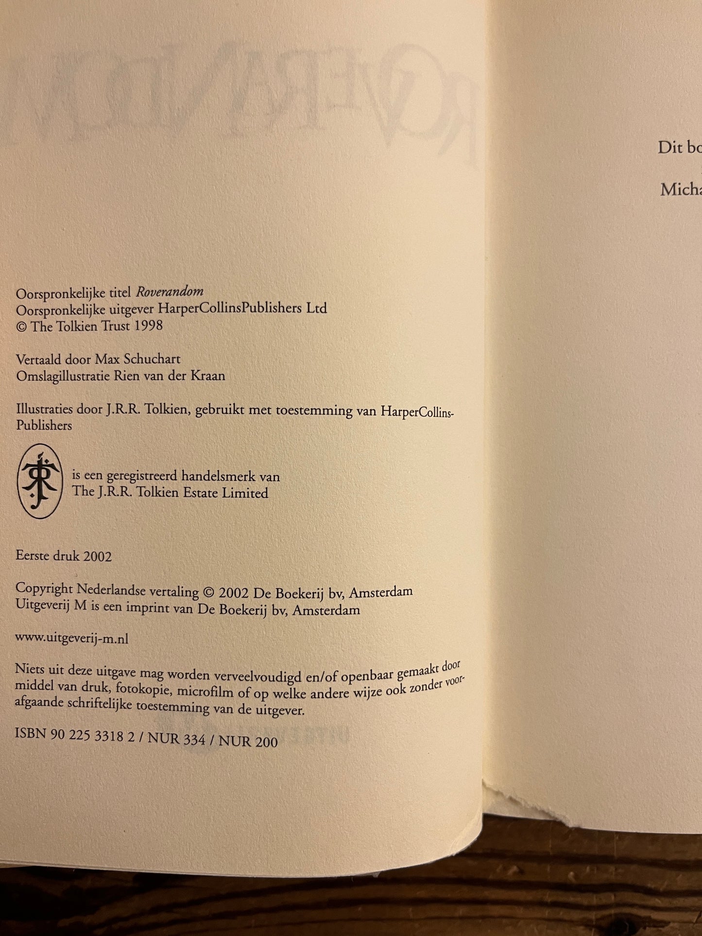 Uitgeverij pagina van boek met de titel 'Roverandom' door J.R.R. Tolkien op een houten achtergrond 